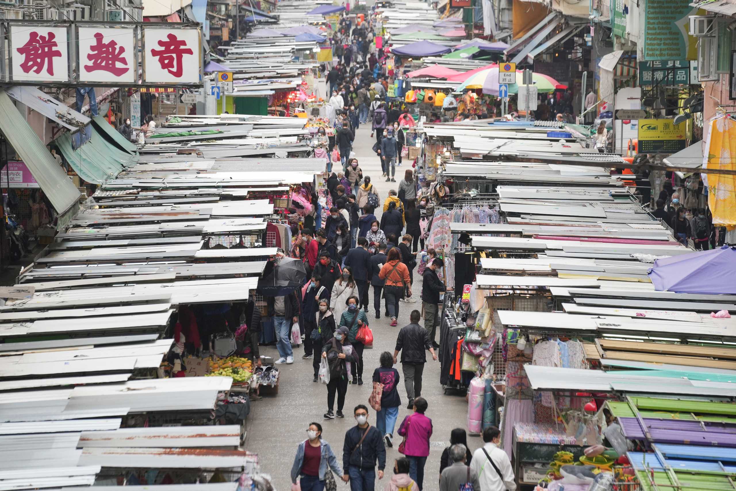 People wearing face masks, following the coronavirus disease (COVID-19) outbreak, walk on a street market in Hong Kong, China February 16, 2022. REUTERS