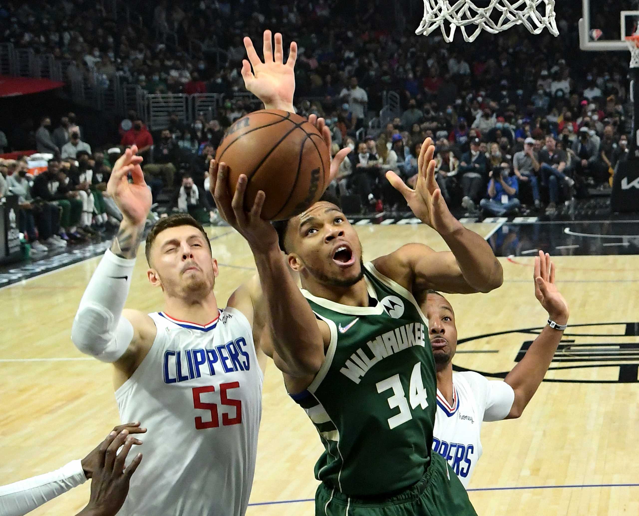 Feb 6, 2022; Los Angeles, California, USA;  Milwaukee Bucks forward Giannis Antetokounmpo (34) is fouled as he drives for a basket past Los Angeles Clippers forward Norman Powell (24) and center Isaiah Hartenstein (55) in the first half at Crypto.com Arena. Mandatory Credit: Jayne Kamin-Oncea-USA TODAY Sports