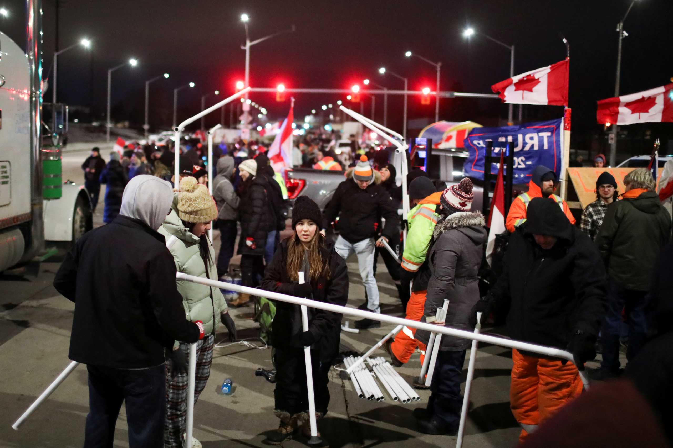 People erect a tent as truck drivers and supporters continue to block access to the Ambassador Bridge, which links Detroit and Windsor, in protest against coronavirus disease (COVID-19) vaccine mandates, in Windsor, Ontario, Canada February 10, 2022. REUTERS