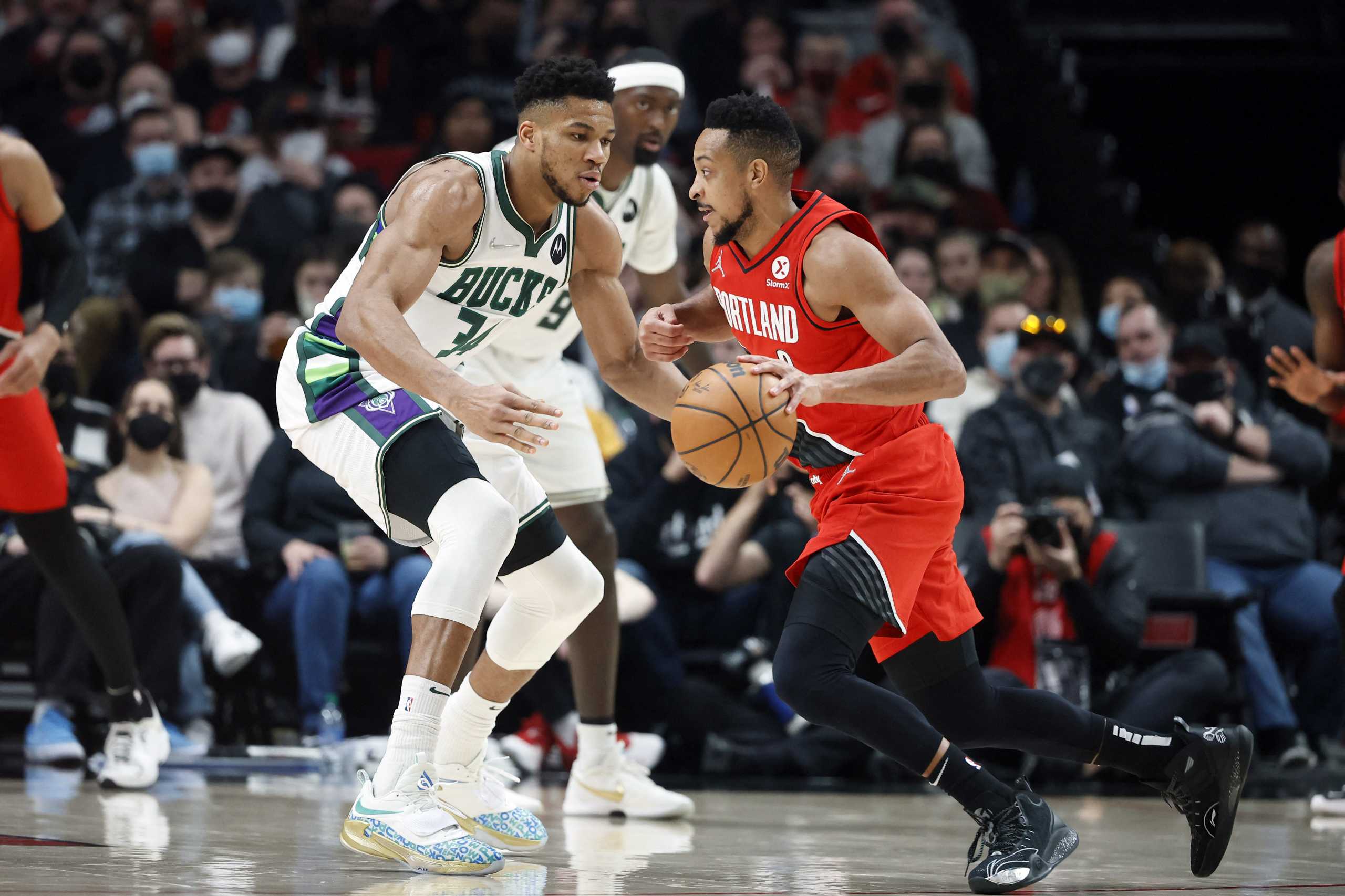 Feb 5, 2022; Portland, Oregon, USA; Portland Trail Blazers shooting guard CJ McCollum (3) moves the ball against Milwaukee Bucks power forward Giannis Antetokounmpo (34) during the first half at Moda Center. Mandatory Credit: Soobum Im-USA TODAY Sports