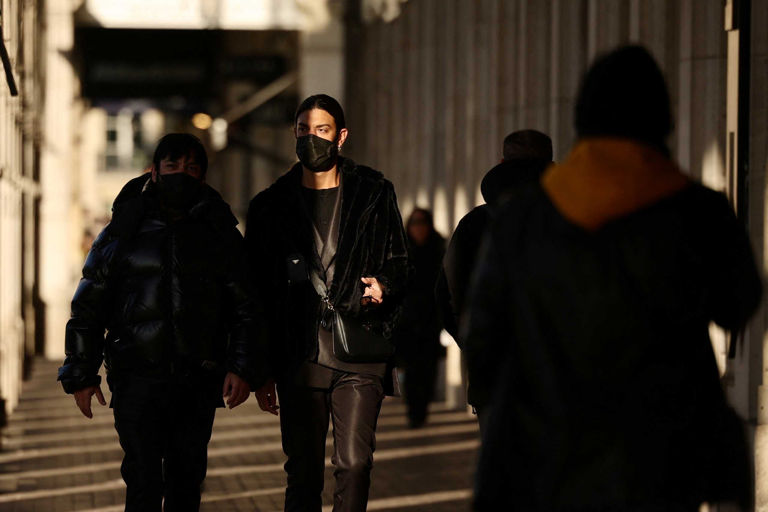 People, wearing protective face masks, walk below the arcades of the Rue de Rivoli in Paris, France, February 11, 2022. REUTERS