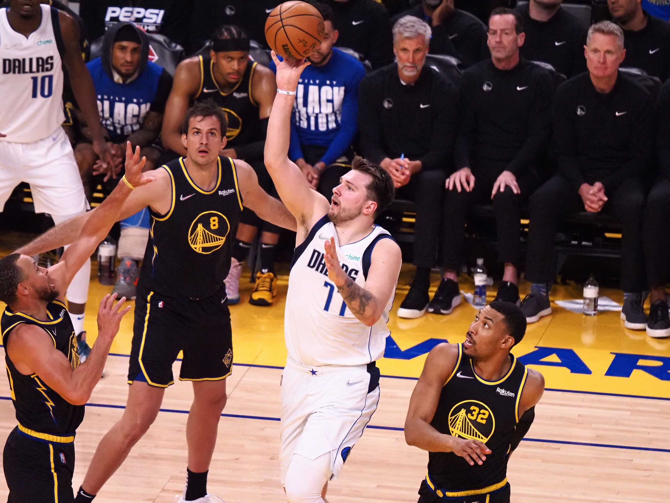 Feb 27, 2022; San Francisco, California, USA; Dallas Mavericks guard Luka Doncic (77) shoots the ball against Golden State Warriors guard Stephen Curry (30), forward Nemanja Bjelica (8) and forward Otto Porter Jr. (32) during the third quarter at Chase Center. Mandatory Credit: Kelley L Cox-USA TODAY Sports