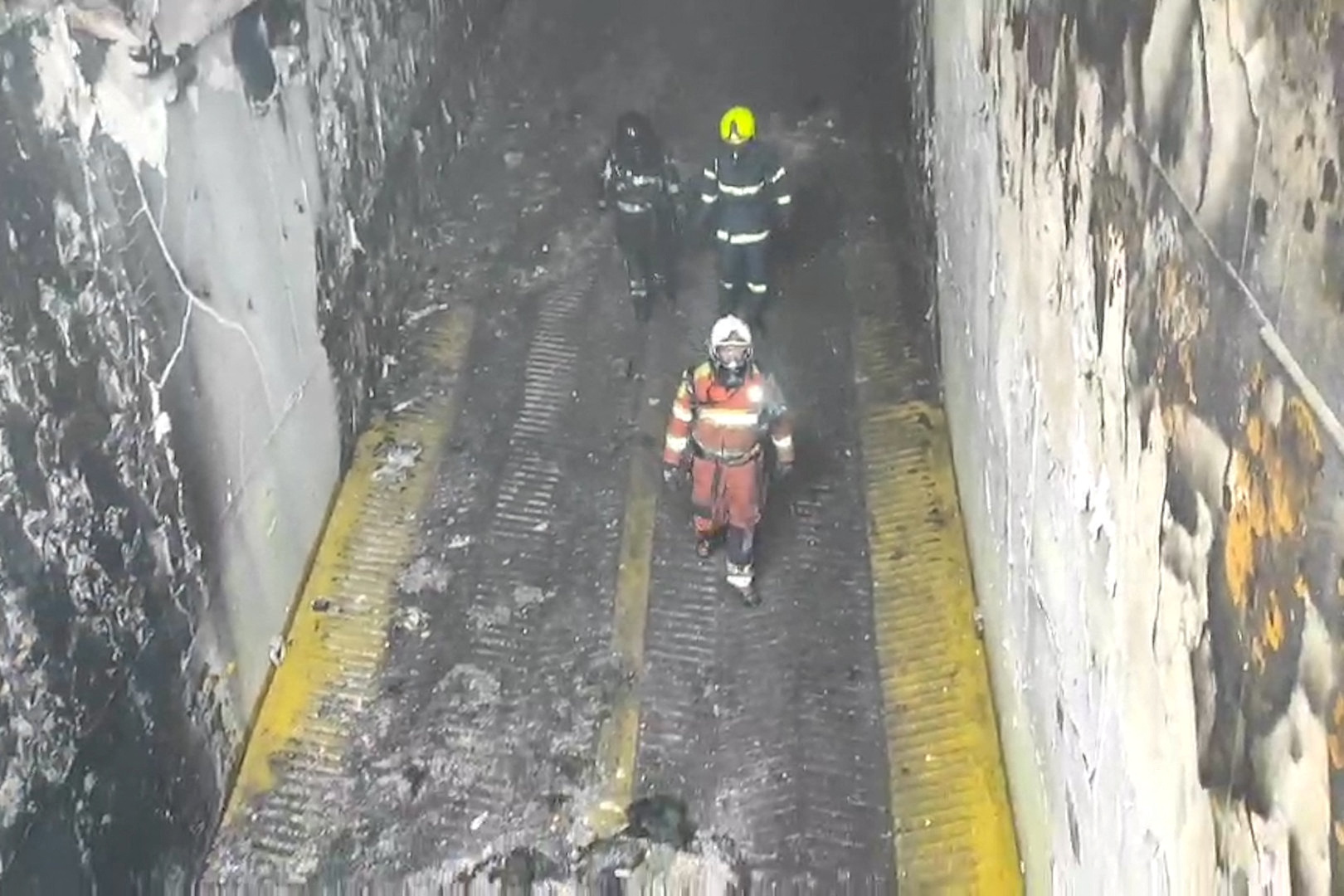 Firefighters are seen on the Italian-flagged Euroferry Olympia, which caught fire early on Friday while sailing from Greece to Italy, off the coast of the island of Corfu, Greece, in this still image taken from a handout video released February 21, 2022. Hellenic Fire Service