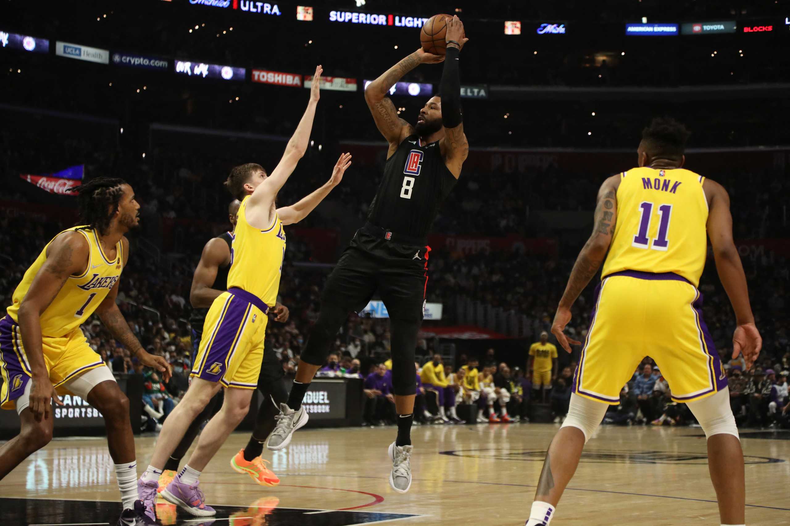 Feb 3, 2022; Los Angeles, California, USA; Los Angeles Clippers forward Marcus Morris Sr. (8) shoots a ball over Los Angeles Lakers guard Austin Reaves (15) during the third quarter at Crypto.com Arena. The Clippers won 111-110. Mandatory Credit: Kiyoshi Mio-USA TODAY Sports