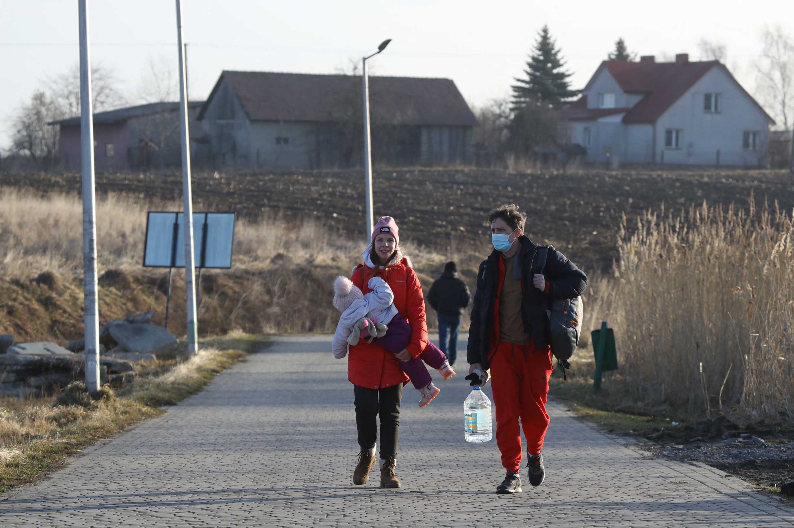 People stand at the border crossing between Poland and Ukraine, after Russian President Vladimir Putin authorized a military operation in eastern Ukraine, in Medyka, Poland, February 24, 2022. REUTERS