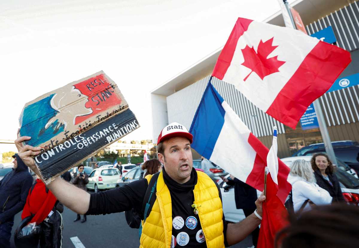 A French activist holds a poster reading "Resistance" before the start of their "Convoi de la liberte" (The Freedom Convoy), a vehicular convoy protest converging on Paris to protest coronavirus disease (COVID-19) vaccine and restrictions in Nice, France, February 9, 2022. REUTERS