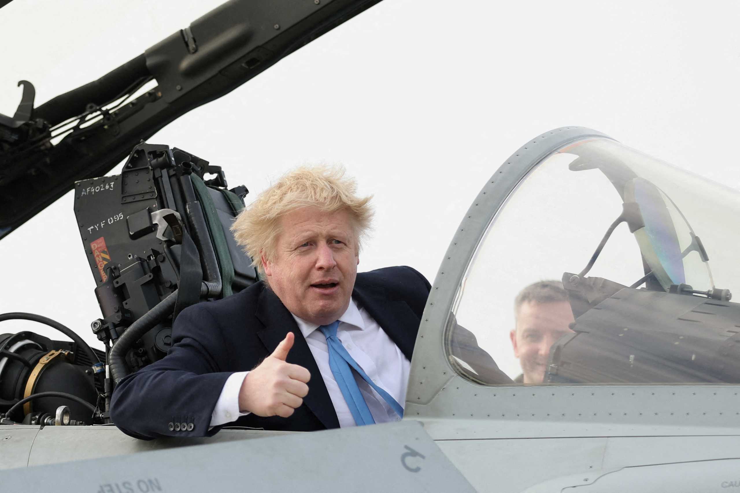 FILE PHOTO: British Prime Minister Boris Johnson gestures from a military aeroplane during his visit at the Royal Air Force Station Waddington, in Waddington, Lincolnshire, Britain February 17, 2022. REUTERS