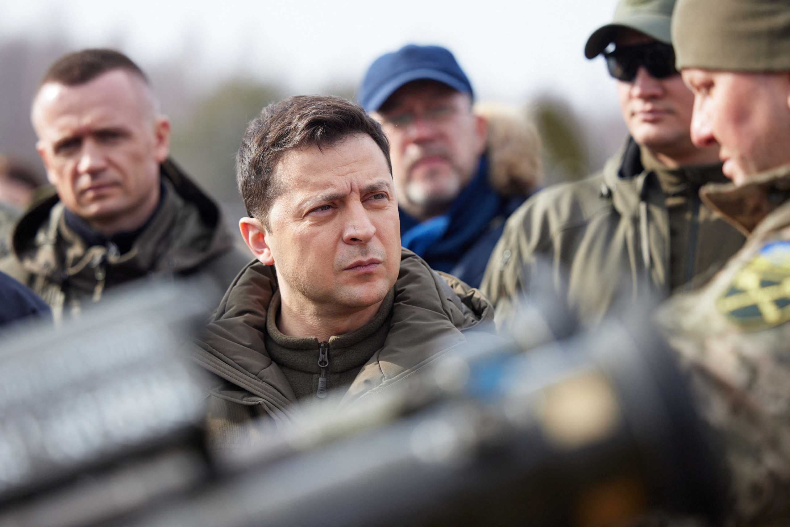 Ukrainian President Volodymyr Zelenskiy examines weapons as he attends tactical military exercises held by the country's armed forces at a training ground in the Rivne Region, Ukraine February 16, 2022. Ukrainian Presidential Press Service