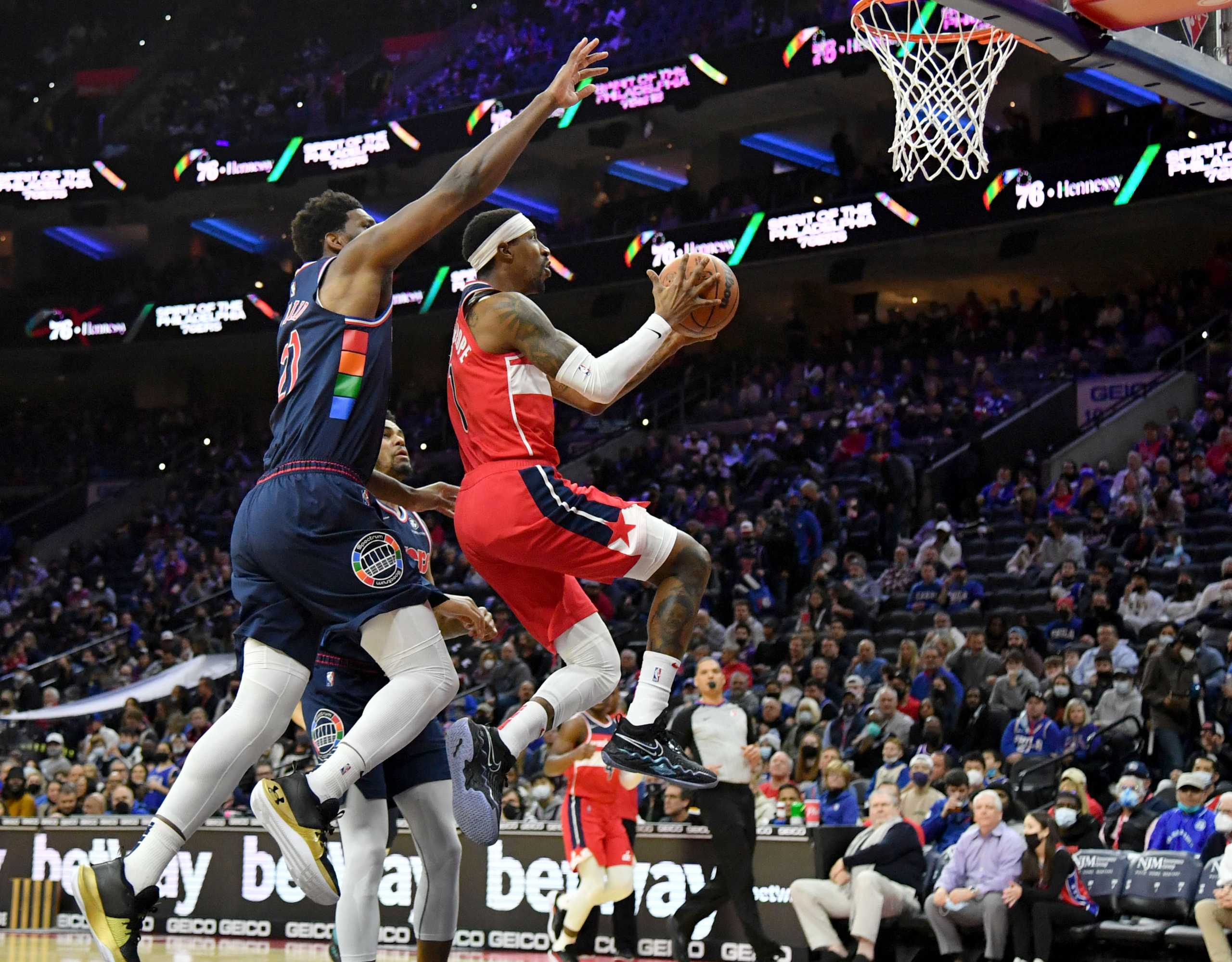 Feb 2, 2022; Philadelphia, Pennsylvania, USA; Washington Wizards guard Kentavious Caldwell-Pope (1) drives to the basket against Philadelphia 76ers center Joel Embiid (21) during the first quarter at Wells Fargo Center. Mandatory Credit: Eric Hartline-USA TODAY Sports
