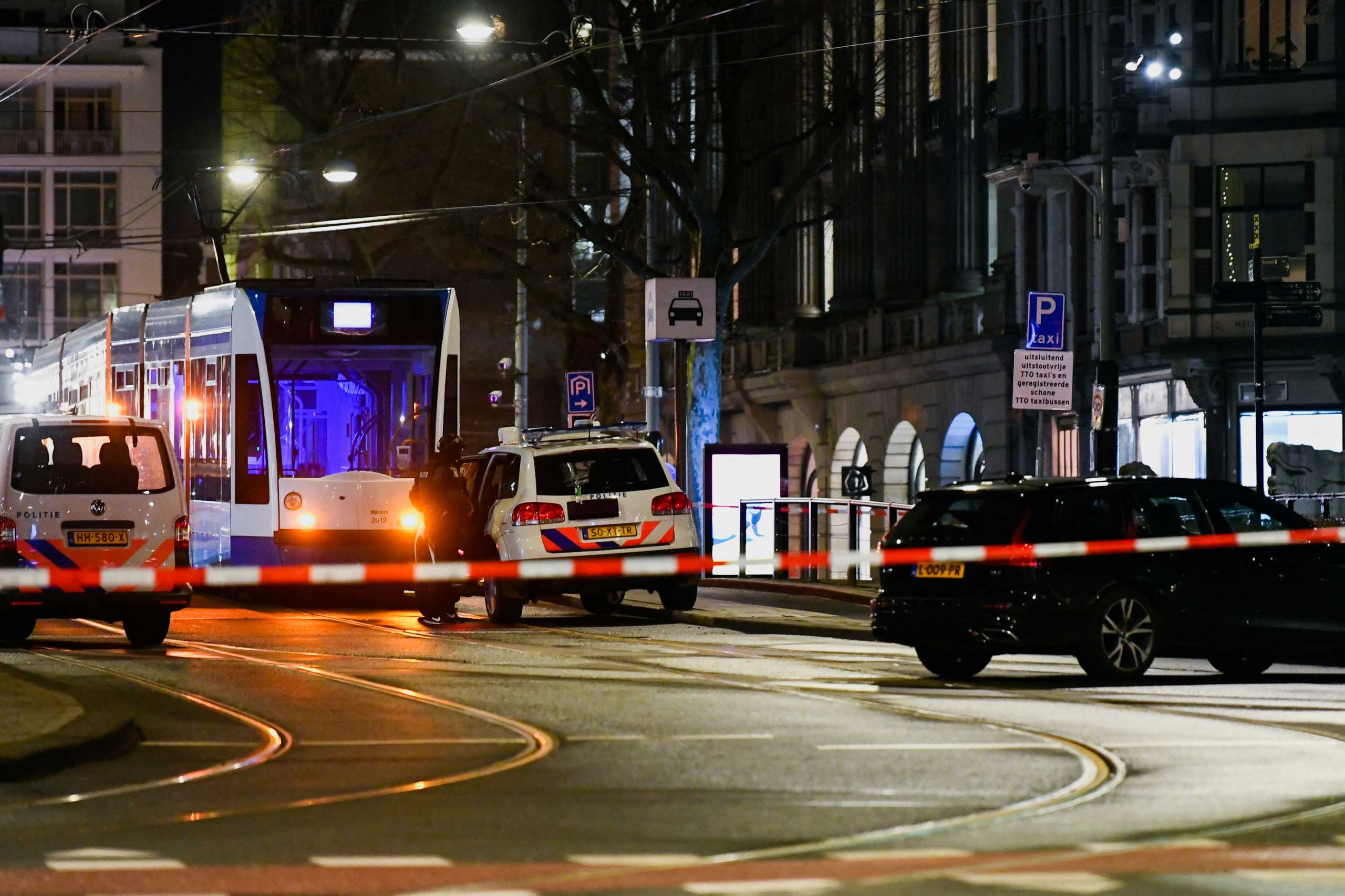 A police officer stands next to a police vehicle near an Apple store in central Amsterdam during a hostage incident in the store, in Amsterdam, Netherlands February 22, 2022. REUTERS