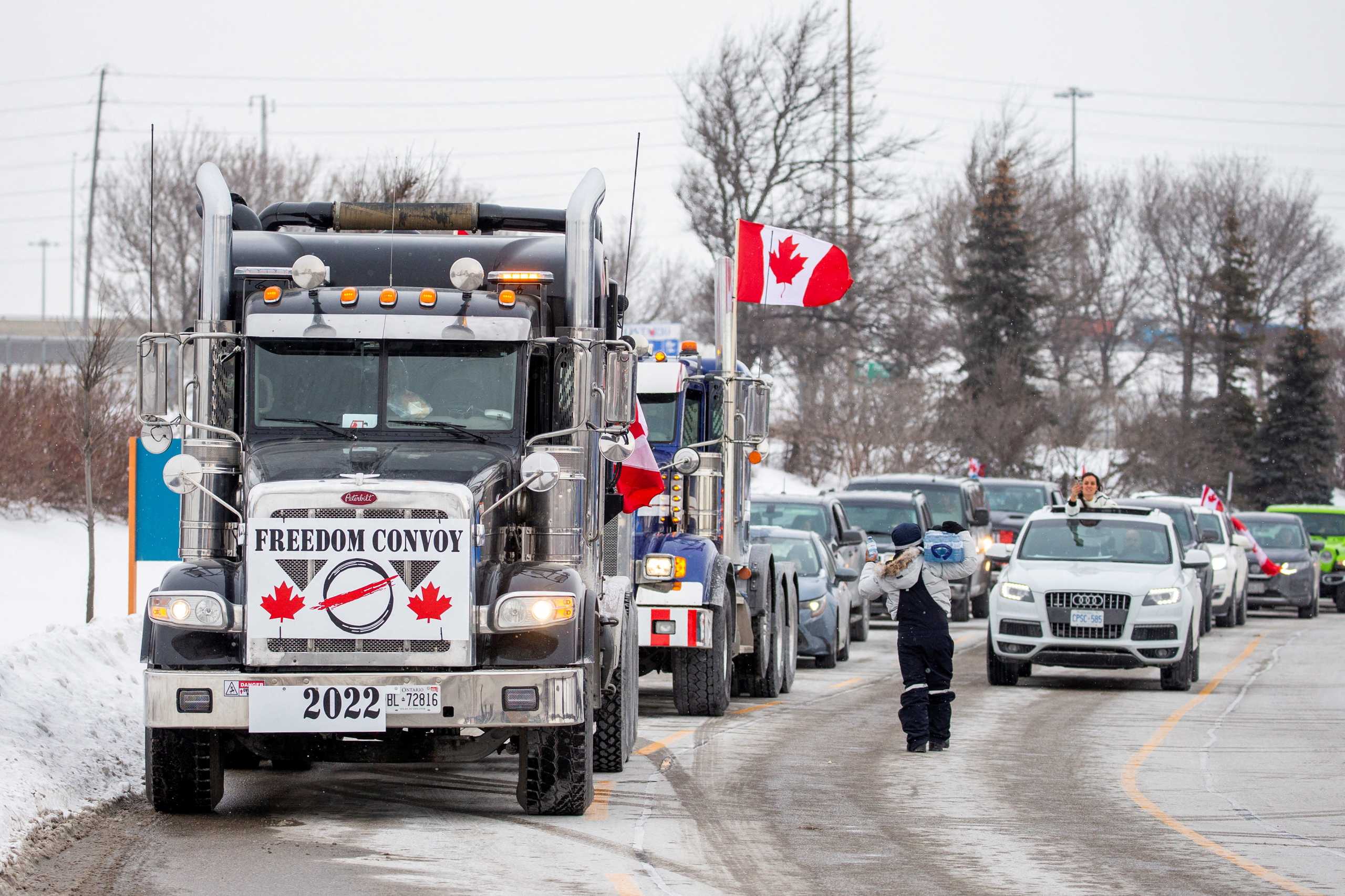 FILE PHOTO: People gather to support truck drivers on their way to Ottawa in protest of coronavirus disease (COVID-19) vaccine mandates for cross-border truck drivers, in Toronto, Ontario, Canada, January 27, 2022. REUTERS
