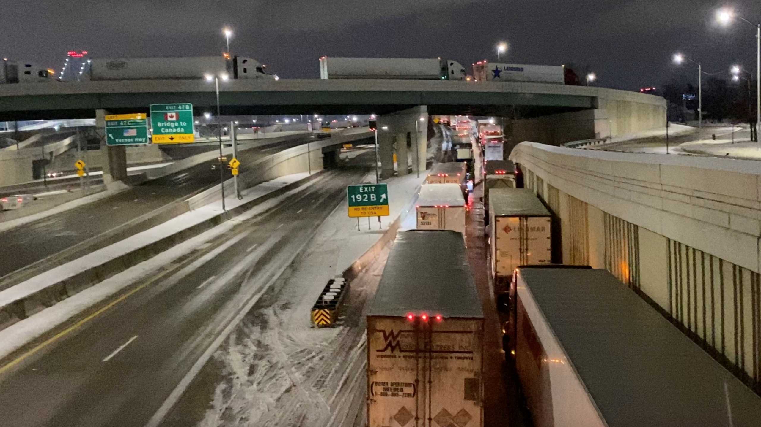 Truckers stand in line as they block the Ambassador Bridge (not pictured) on the I-75 and I-96 highways in Detroit, Michigan, U.S., February 7, 2022,  in this still image taken from a handout video obtained by Reuters on February 8, 2022. Macomb County Scanner