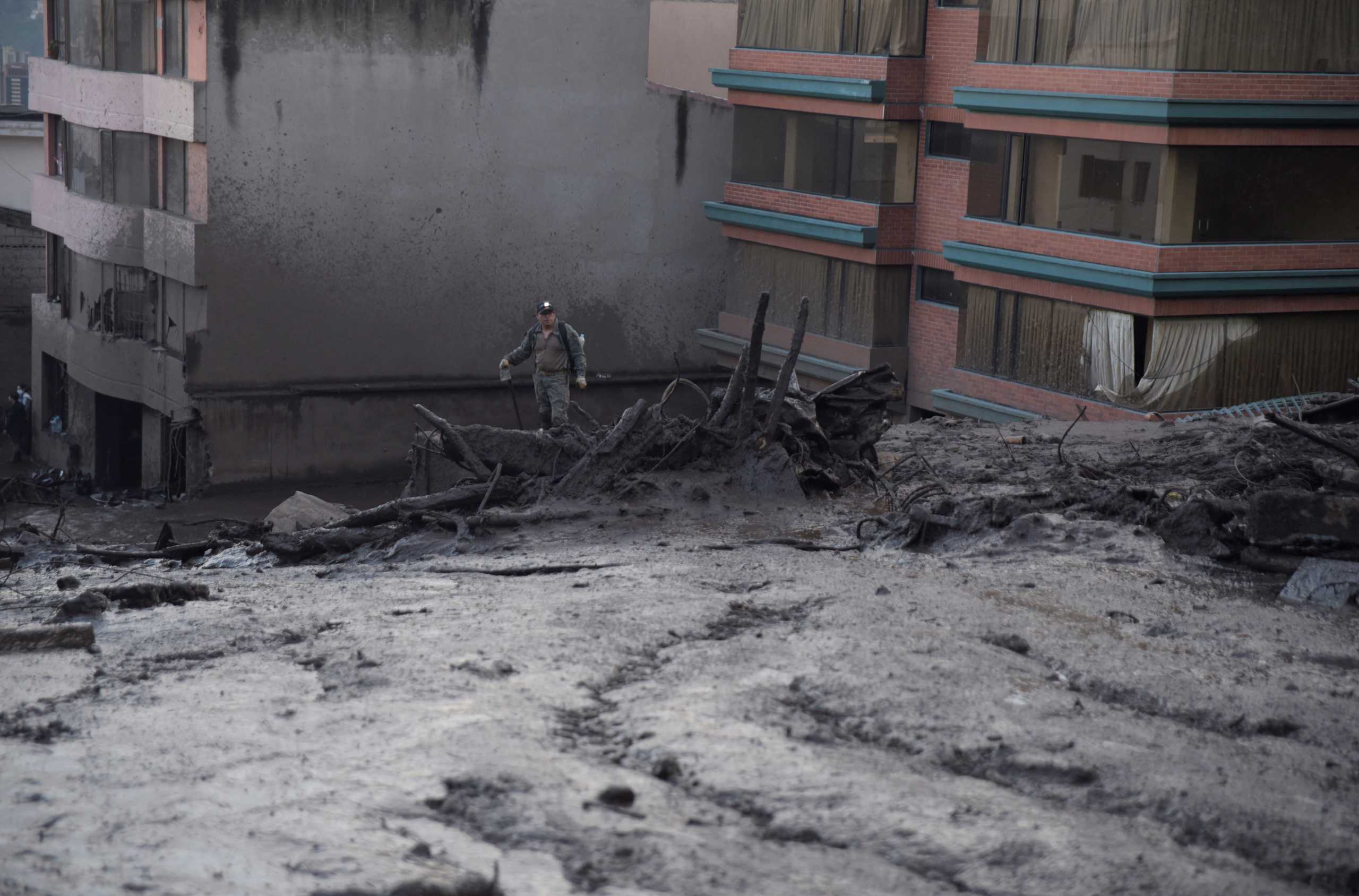 A soldier stands on a mount of debris after torrential rains caused a landslide, sending mud and rocks down on residences and affecting electricity provision, in Quito, Ecuador, February 1, 2022. Picture taken February 1, 2022. REUTERS