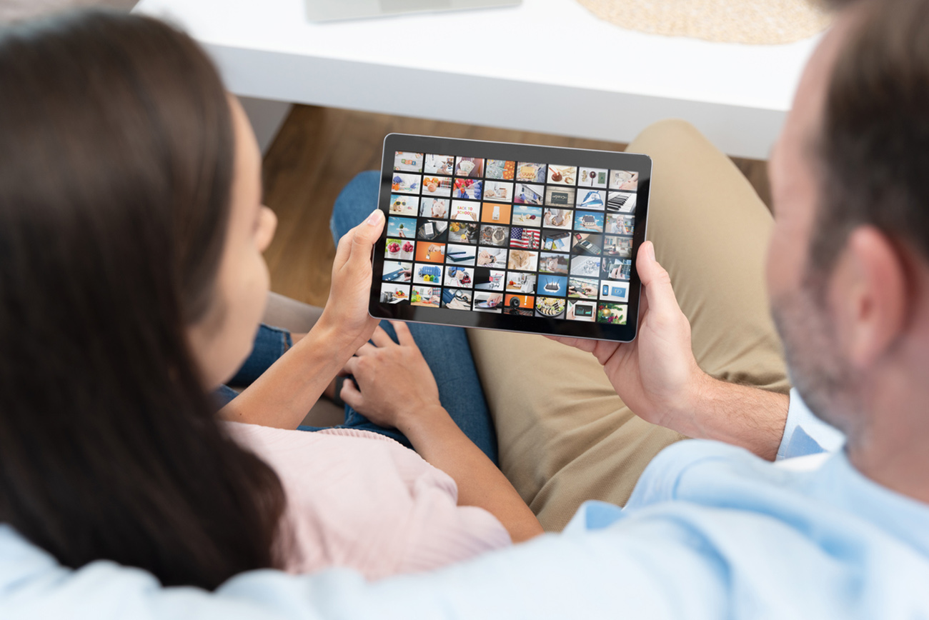 Couple watching TV series on tablet. Video on demand service.