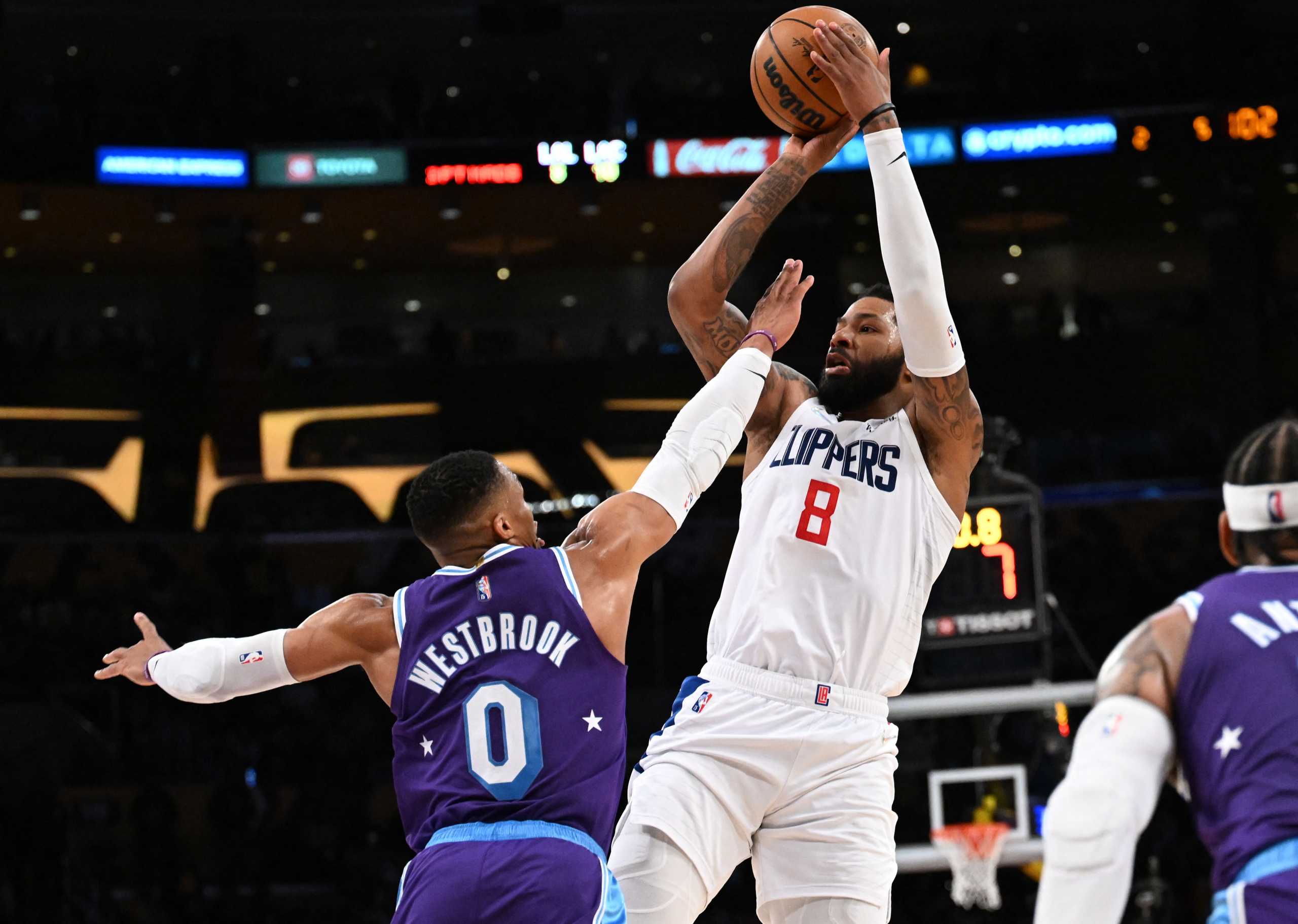 Feb 25, 2022; Los Angeles, California, USA;   Los Angeles Clippers forward Marcus Morris Sr. (8) hits a three point basket over Los Angeles Lakers guard Russell Westbrook (0) in the fourth quarter of the game at Crypto.com Arena. Mandatory Credit: Jayne Kamin-Oncea-USA TODAY Sports