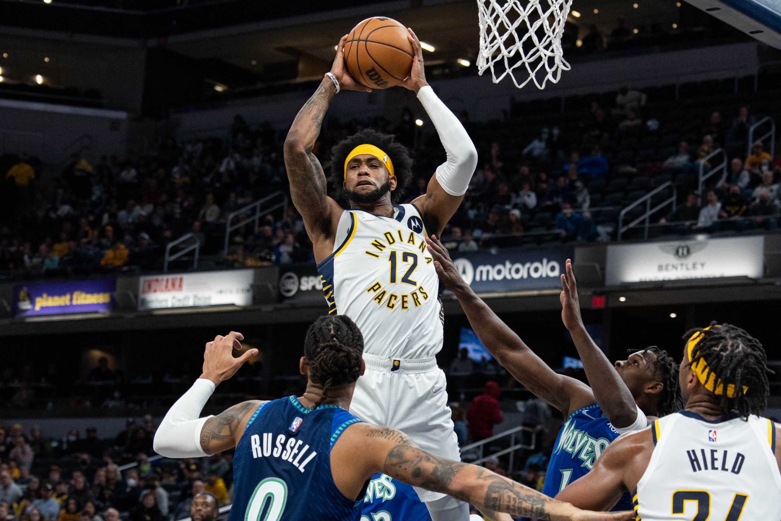 Feb 13, 2022; Indianapolis, Indiana, USA; Indiana Pacers forward Oshae Brissett (12) rebounds the ball in the second half against the Minnesota Timberwolves at Gainbridge Fieldhouse. Mandatory Credit: Trevor Ruszkowski-USA TODAY Sports