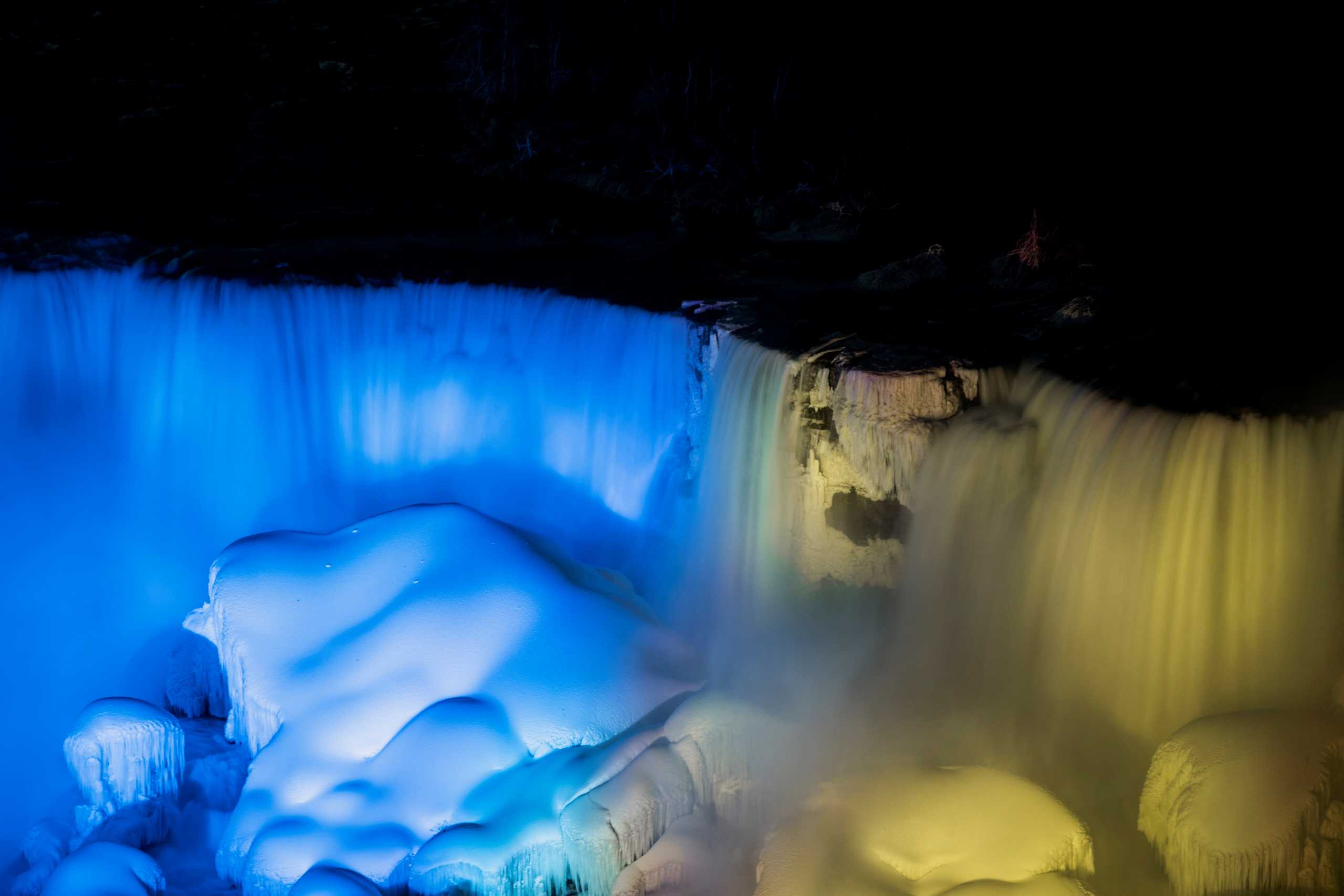 The American Falls and Bridal Veil Falls are lit in the colours of the Ukrainian flag, following the Russian invasion in Ukraine, as seen from Niagara Falls, Ontario, Canada February 27, 2022.  REUTERS