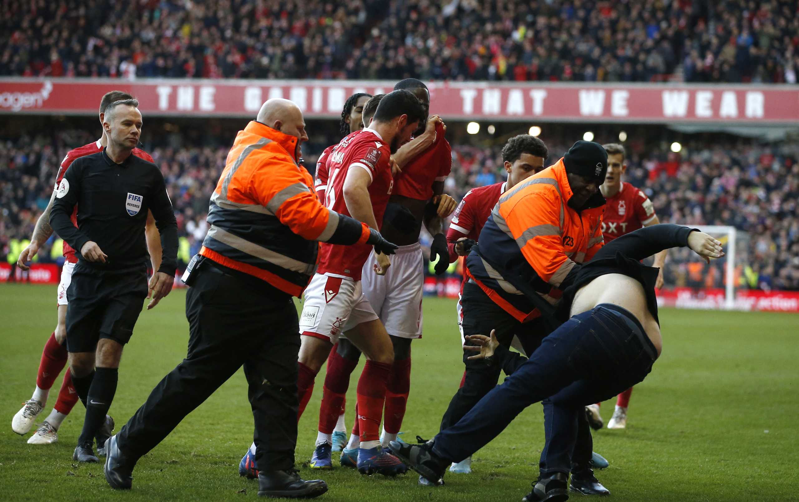Soccer Football - FA Cup - Fourth Round - Nottingham Forest v Leicester City - The City Ground, Nottingham, Britain - February 6, 2022 A Leicester City fan is detained by stewards after invading the pitch REUTERS