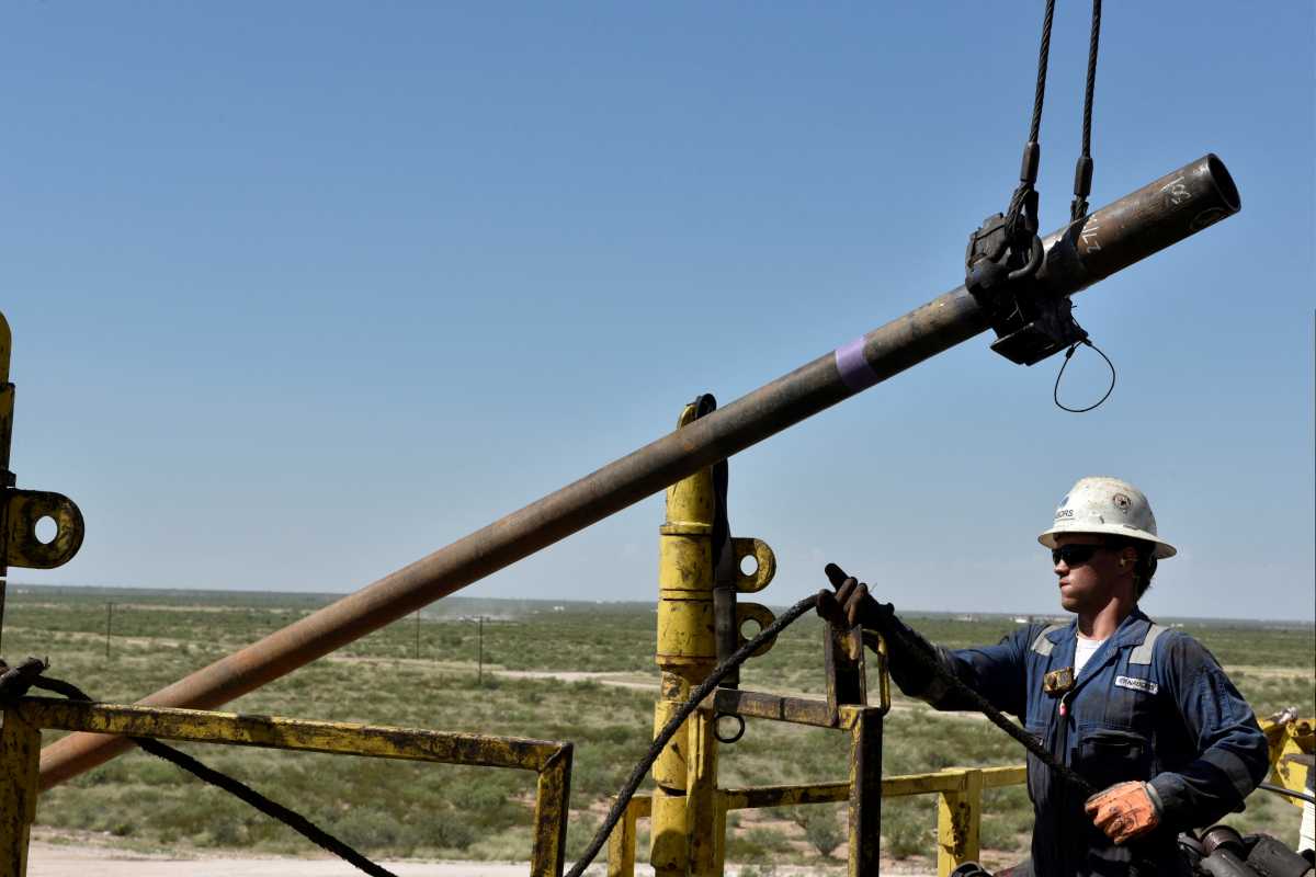 FILE PHOTO: A drilling crew member raises drill pipe onto the drilling rig floor on an oil rig in the Permian Basin near Wink, Texas U.S. August 22, 2018. Picture taken August 22, 2018. REUTERS