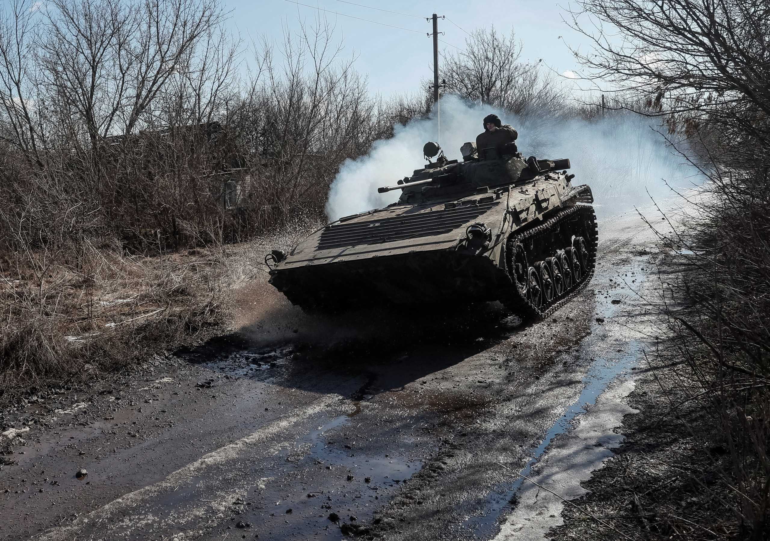 Ukrainian service members ride at a infantry fighting vehicle on the front line near the village of Zaitseve in the Donetsk region, Ukraine February 19, 2022. REUTERS