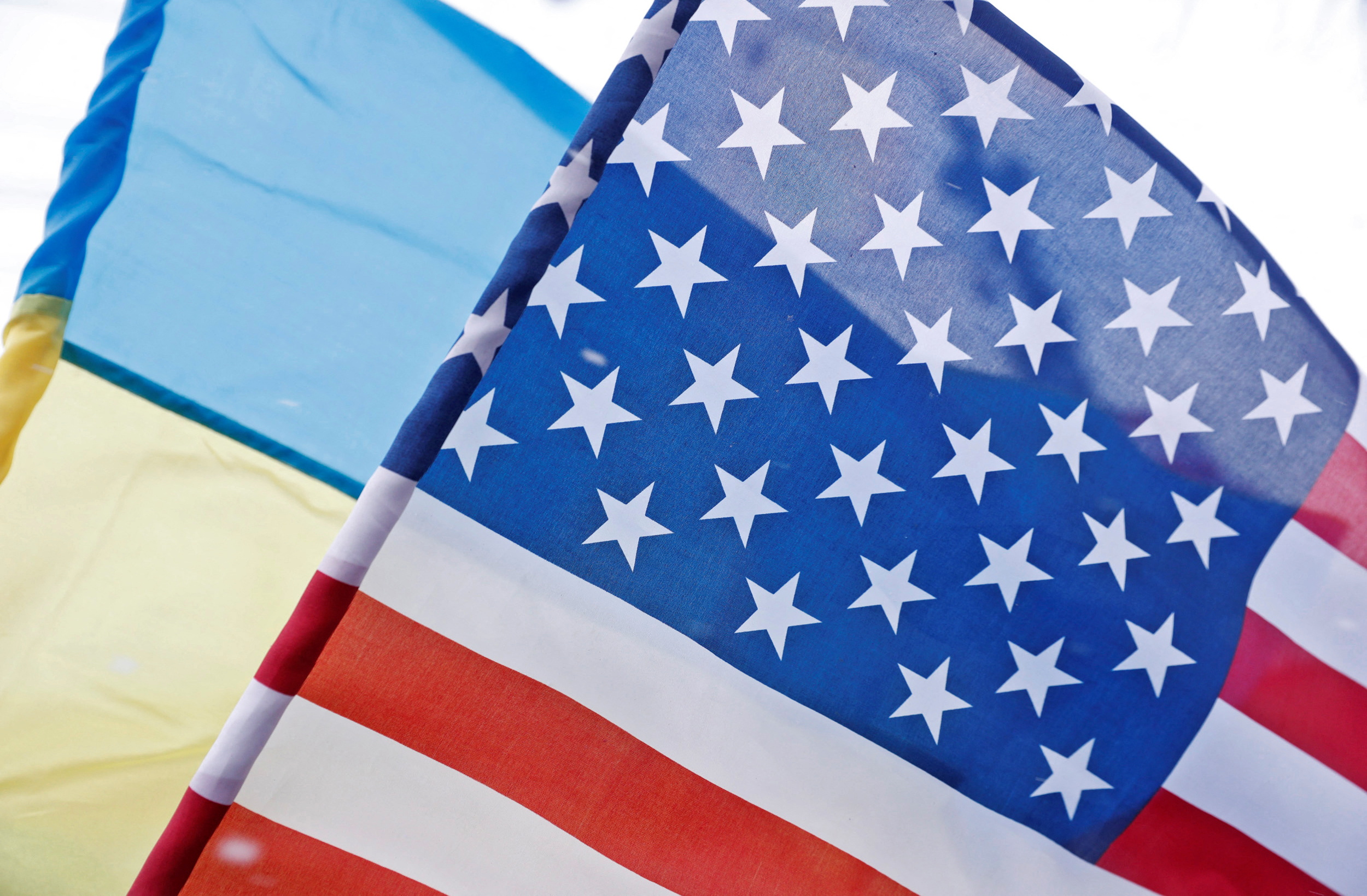The Ukrainian national flag is seen behind the U.S. national flag during a rally of foreign community members in support of Ukraine amid growing tensions with Russia, in Kyiv, Ukraine February 6, 2022. REUTERS