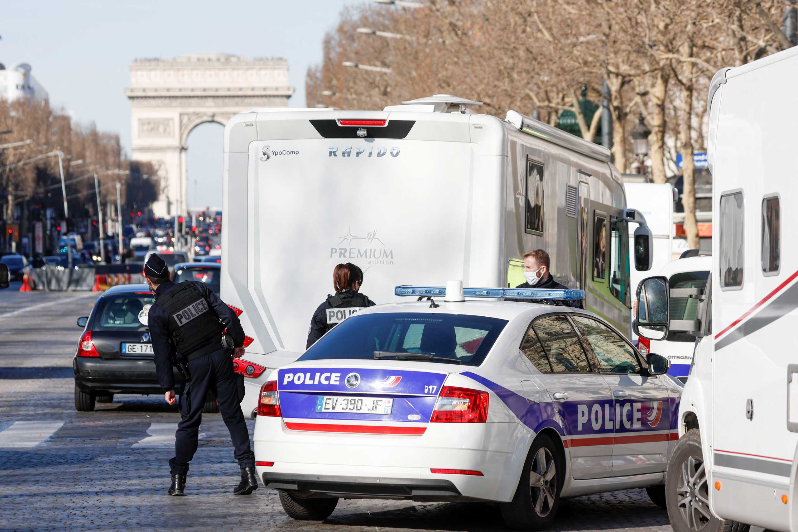 Police officers check a camper van on the Champs-Elysees avenue as French drivers and their "Convoi de la liberte" (The Freedom Convoy), a vehicular convoy protest, arrive in Paris to protest against coronavirus disease (COVID-19) vaccine and restrictions in France, February 12, 2022. REUTERS