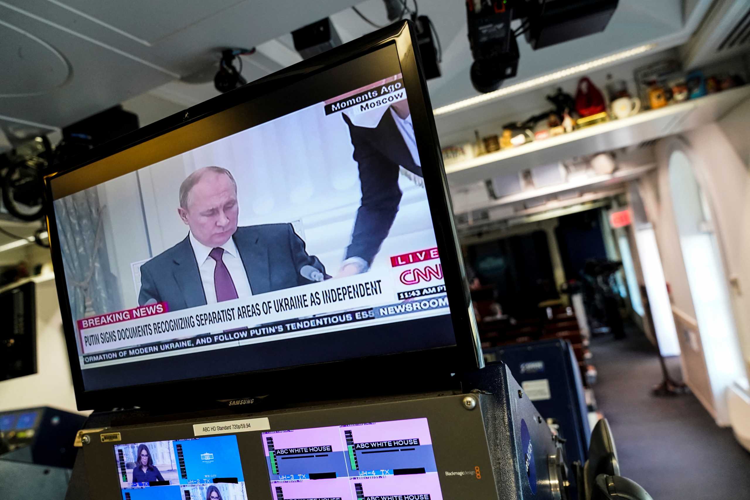 Russian President Vladimir Putin appears on a screen at the White House briefing room during a TV broadcast, signing documents recognizing separatist areas of Ukraine as independent, in Washington, U.S., February 21, 2022. REUTERS