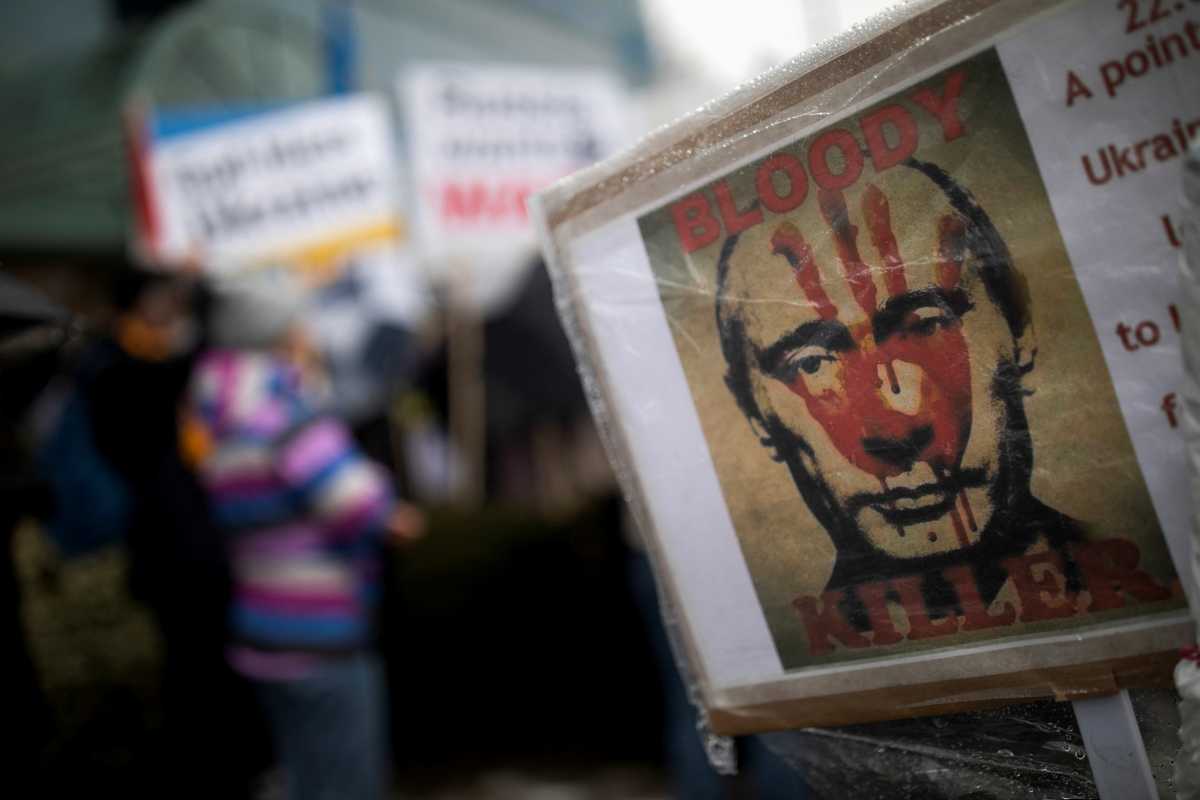 A sign with an image depicting Vladimir Putin is seen during a rally outside the Ukrainian Consulate in Toronto, Ontario, Canada, February 22, 2022. REUTERS