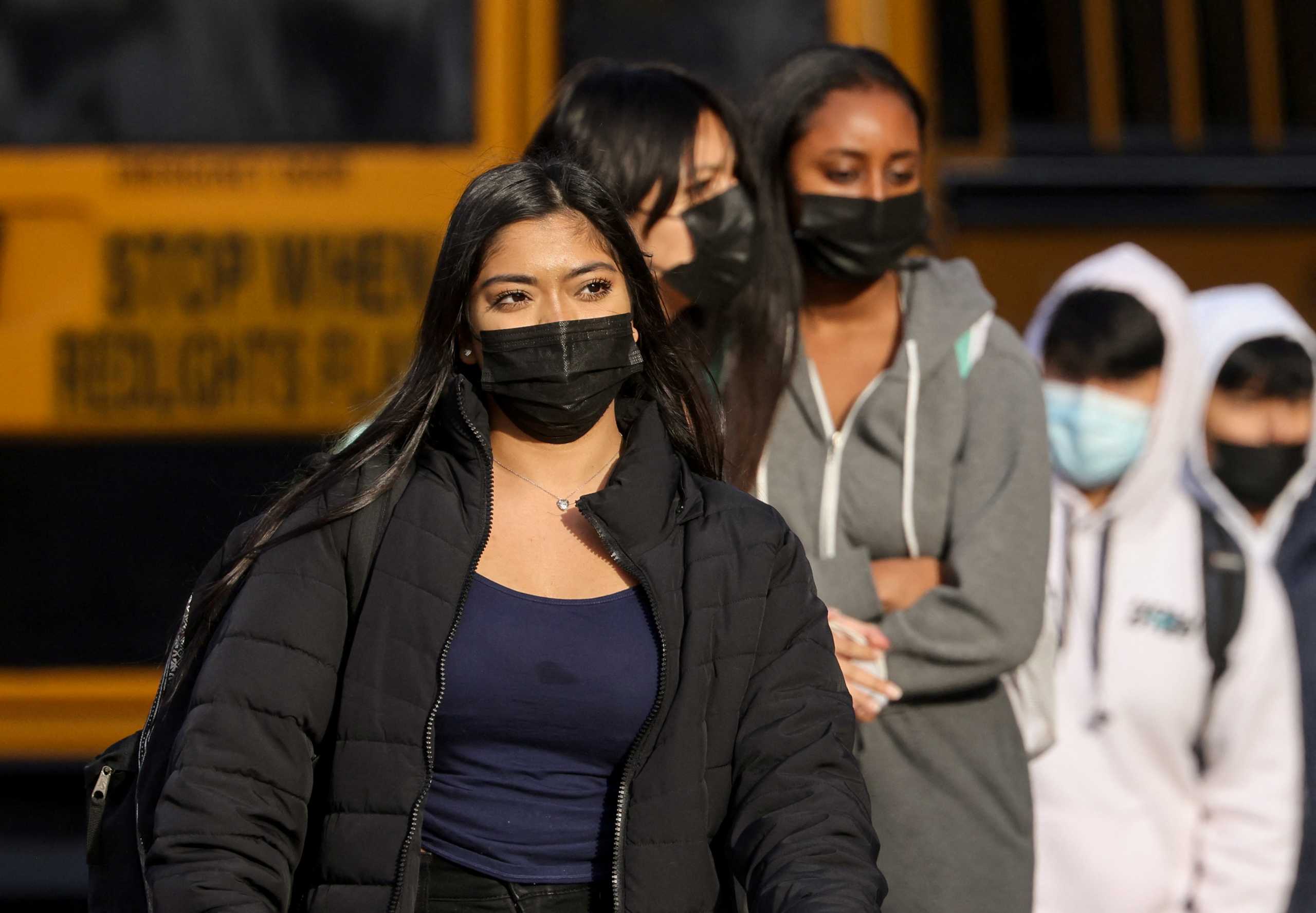 Students leave Washington-Liberty High School in Arlington County which is one of several school districts which sued to stop the mask-optional order by Governor Glenn Youngkin (R), in Arlington, Virginia, U.S., January 25, 2022. REUTERS