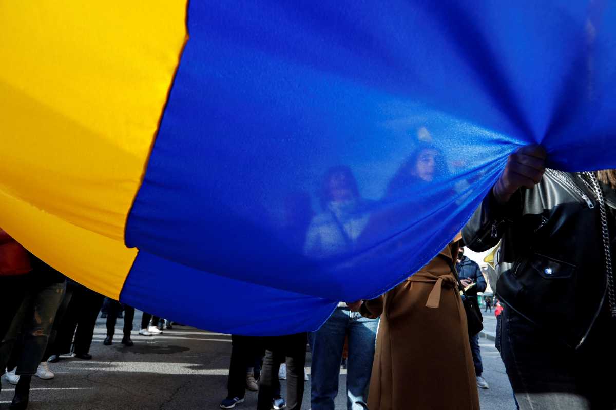 People hold up a Ukrainian flag during an anti-war protest at Piazza della Repubblica, after Russia launched a massive military operation against Ukraine, in Rome, Italy, February 27, 2022. REUTERS
