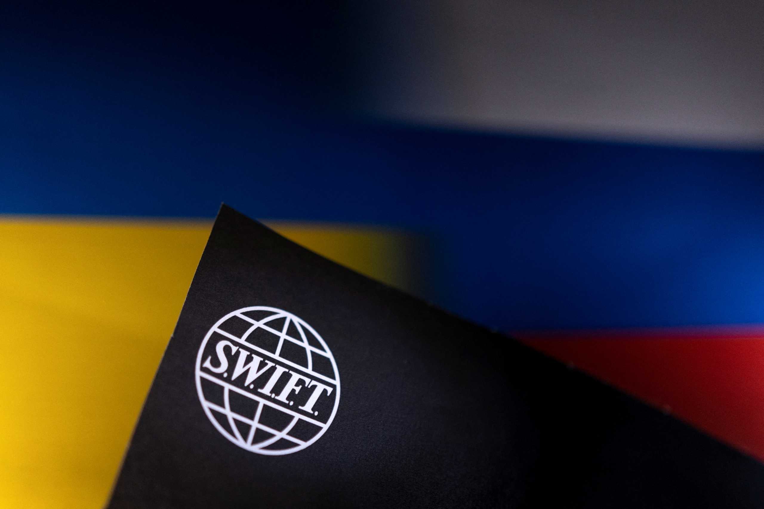 Swift logo is placed on Ukrainian's and Russian's flag colors in this illustration taken, Bosnia and Herzegovina, February 25, 2022. REUTERS