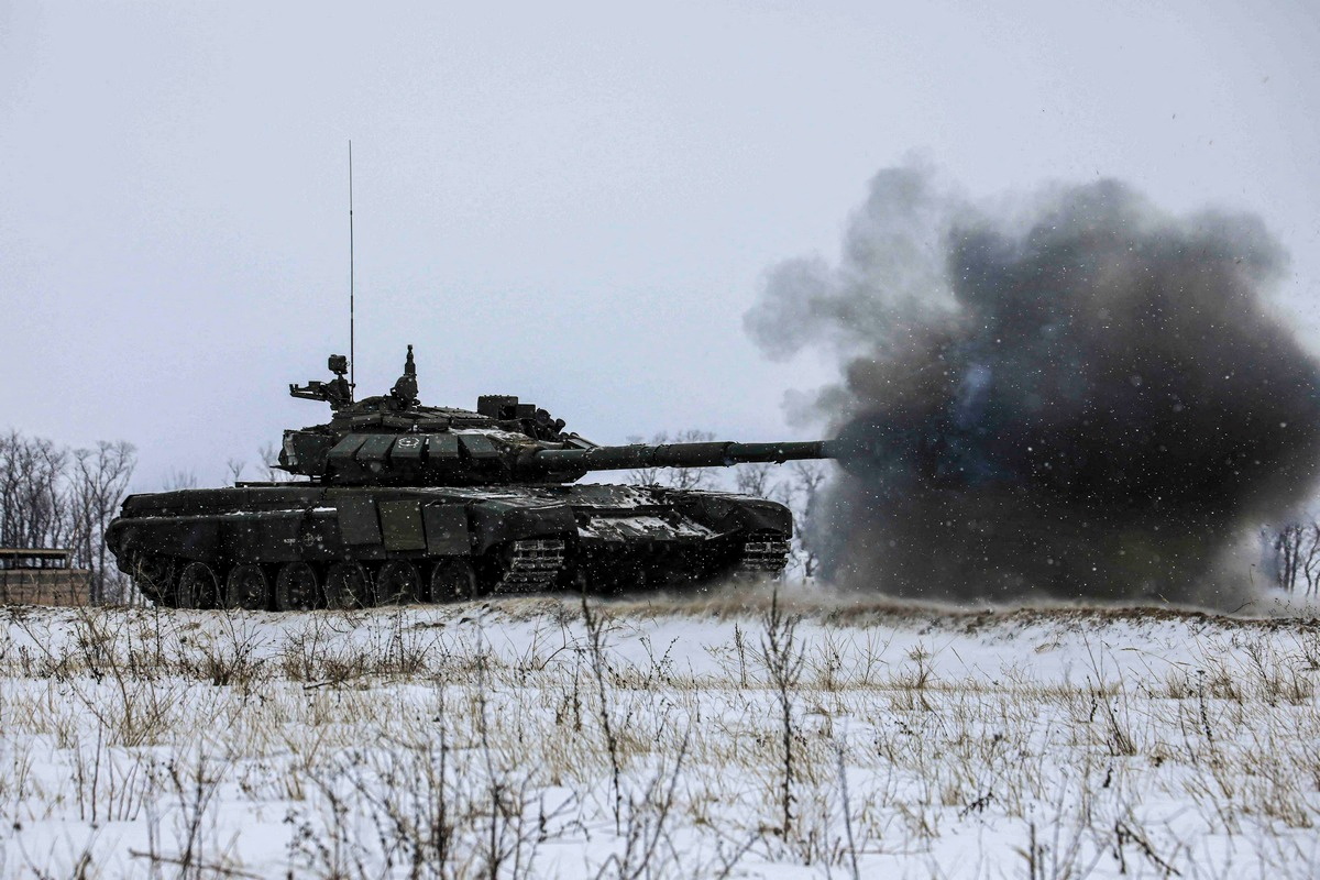 A tank of Russian armed forces fires during military exercises in the Leningrad Region, Russia, in this handout picture released February 14, 2022. Russian Defence Ministry