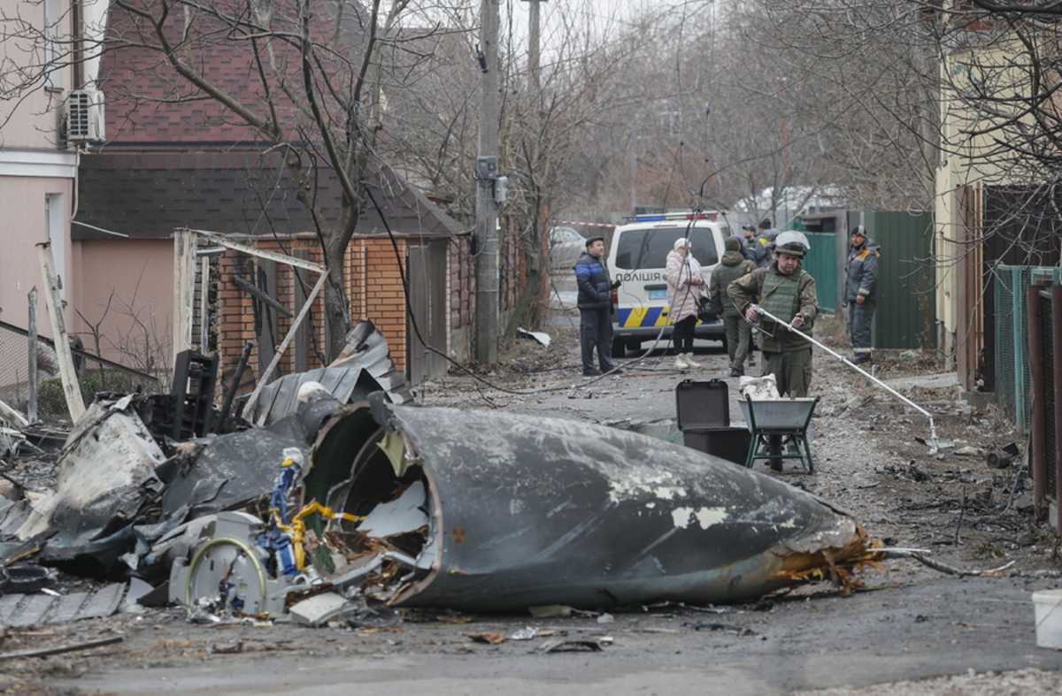 epa09783633 Military personnel walks past the debris of a military plane that was shot down overnight in Kiev, Ukraine, 25 February 2022. Russian troops entered Ukraine on 24 February prompting the country's president to declare martial law.  EPA