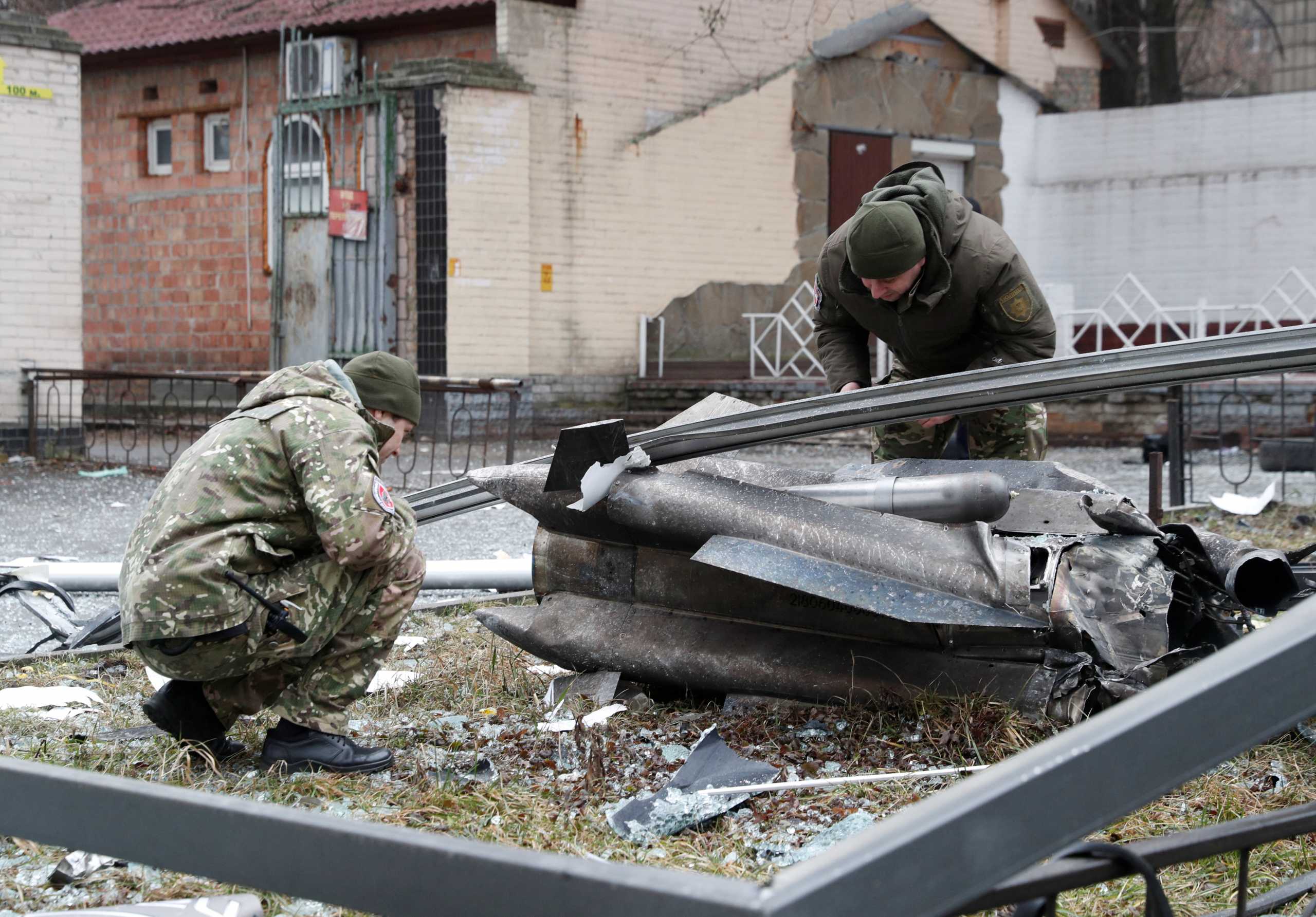 Police officers inspect the remains of a missile that fell in the street, after Russian President Vladimir Putin authorized a military operation in eastern Ukraine, in Kyiv, Ukraine February 24, 2022. REUTERS