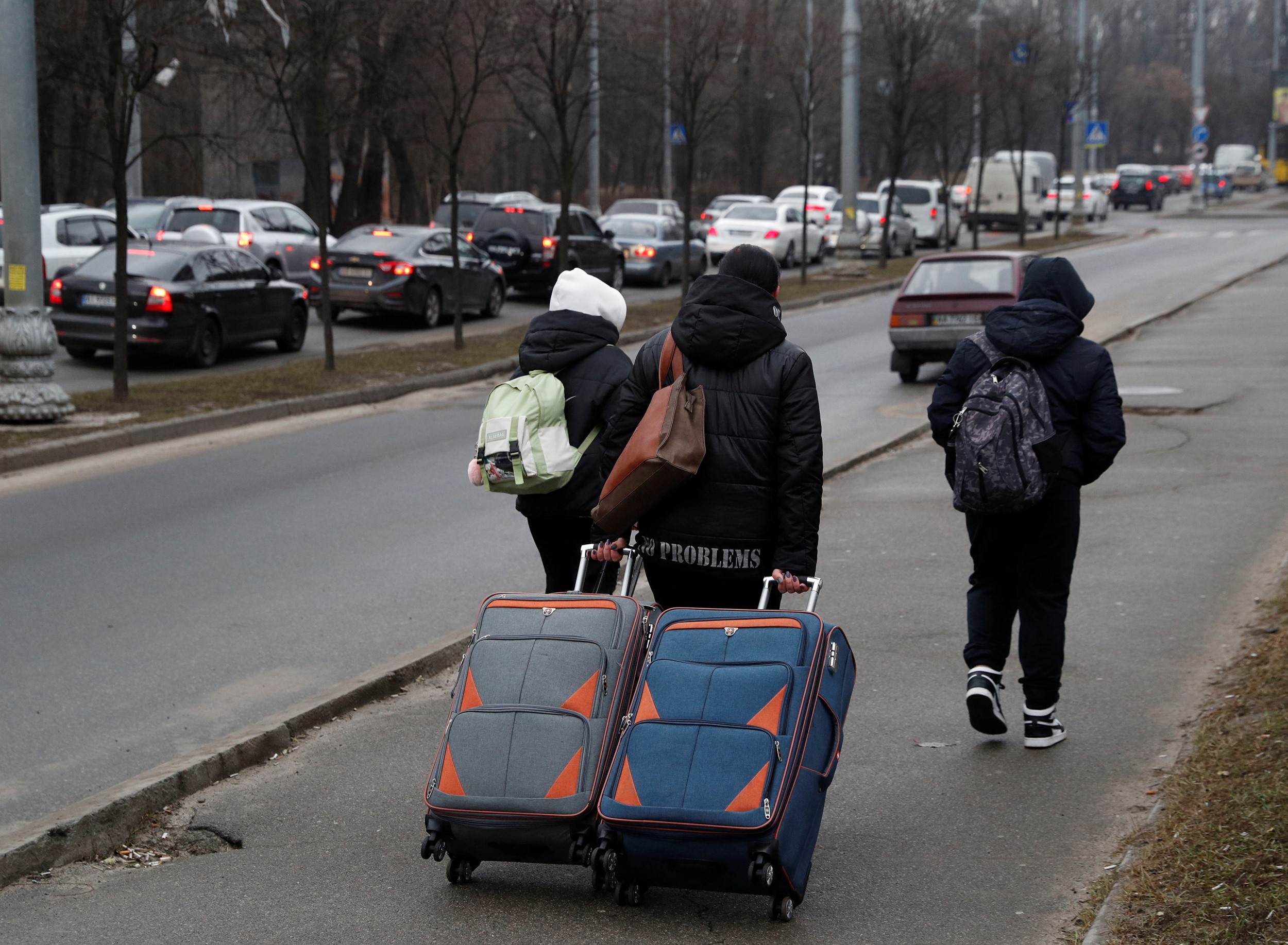 People walk along a street with their luggage, after Russian President Vladimir Putin authorized a military operation in eastern Ukraine, in Kyiv, Ukraine February 24, 2022. REUTERS