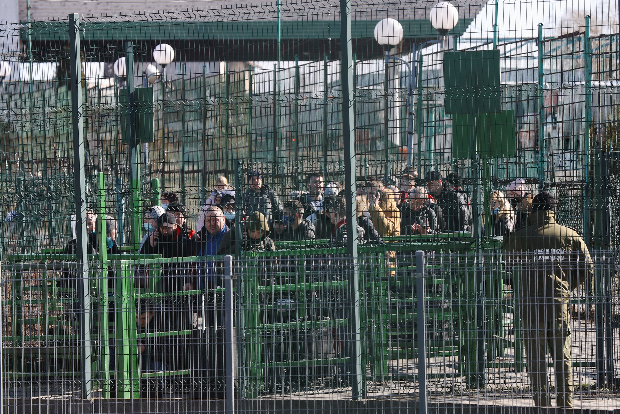 People wait at the Ukranian side of the border crossing between Poland and Ukraine, after Russian President Vladimir Putin authorized a military operation in eastern Ukraine, as seen from Medyka, Poland, February 24, 2022. REUTERS