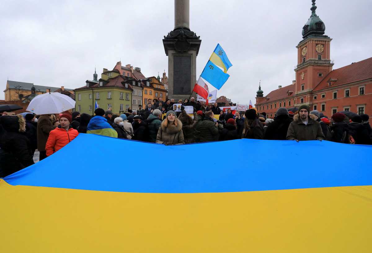 People wave a huge Ukrainian flag during a demonstration in solidarity with Ukraine in Warsaw, Poland February 20, 2022. Jacek Marczewski