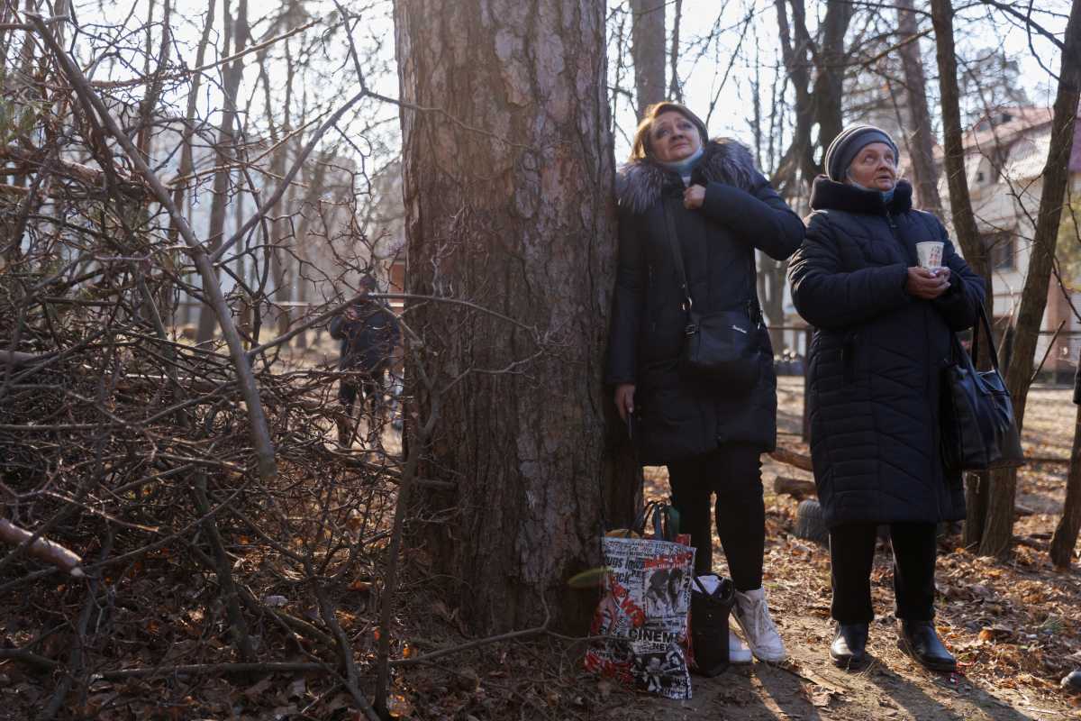 Residents watch rescue efforts at a residential building that was hit by shelling as Russia's attack on Ukraine continues, in Kyiv, Ukraine March 15, 2022. REUTERS