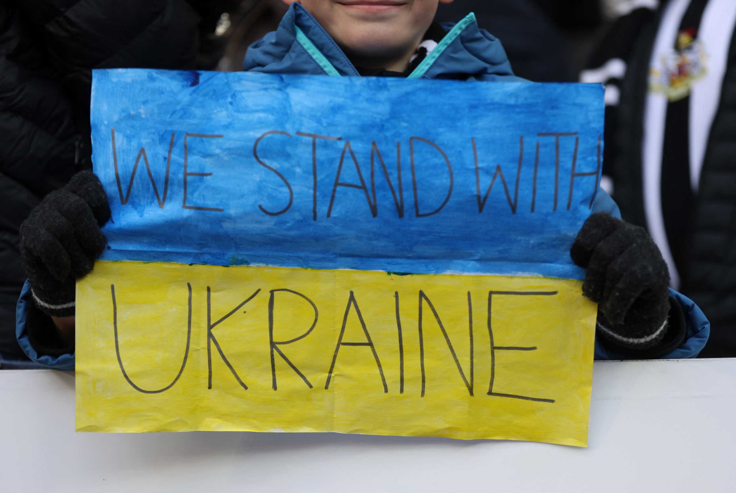 Soccer Football - Premier League - Newcastle United v Brighton & Hove Albion - St James' Park, Newcastle, Britain - March 5, 2022  A fan displays a sign in support of Ukraine amid Russia's invasion inside the stadium before the match Action Images via Reuters