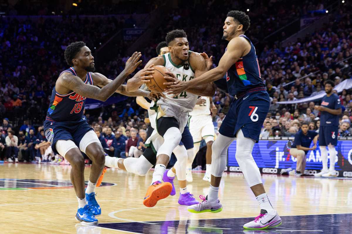 Mar 29, 2022; Philadelphia, Pennsylvania, USA; Milwaukee Bucks forward Giannis Antetokounmpo (34) drives between Philadelphia 76ers forward Tobias Harris (12) and guard Shake Milton (18) during the fourth quarter at Wells Fargo Center. Mandatory Credit: Bill Streicher-USA TODAY Sports