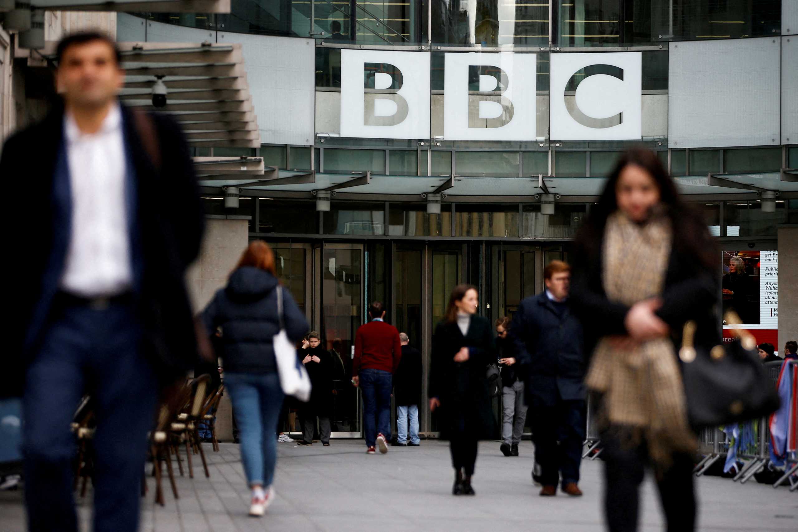 FILE PHOTO: Pedestrians walk past a BBC logo at Broadcasting House in London, Britain, January 29, 2020. REUTERS