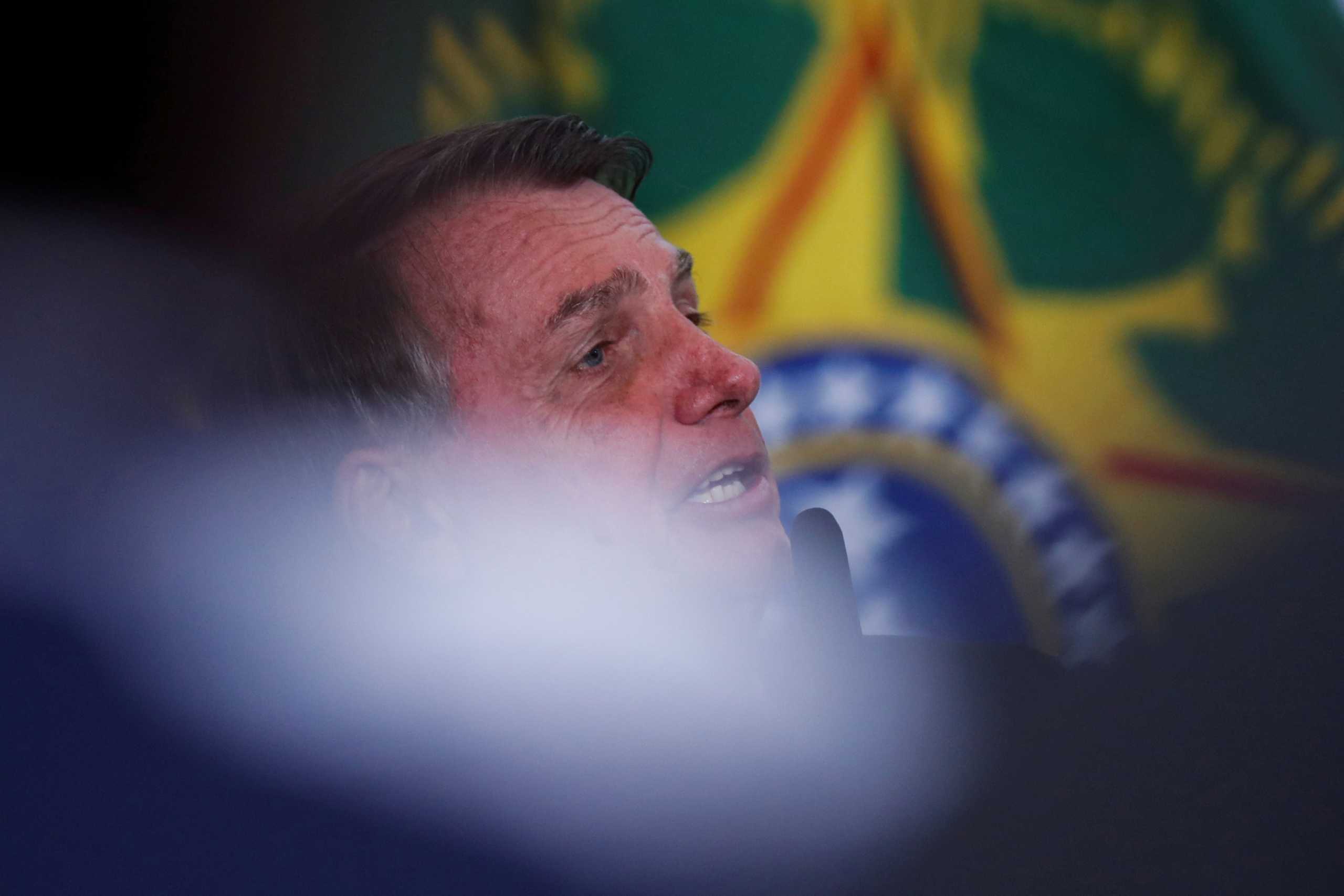 Brazil's President Jair Bolsonaro listens to Brazil's Environment Minister Joaquim Leite at the Planalto Palace in Brasilia, Brazil March 21, 2022.REUTERS