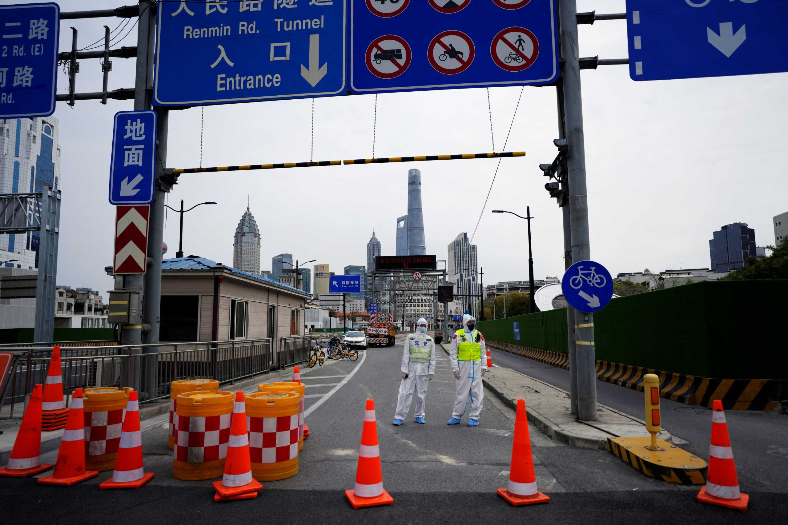 Police officers in protective suits keep watch at an entrance to a tunnel leading to the Pudong area across the Huangpu river, after traffic restrictions amid the lockdown to contain the spread of the coronavirus disease (COVID-19) in Shanghai, China March 28, 2022. REUTERS