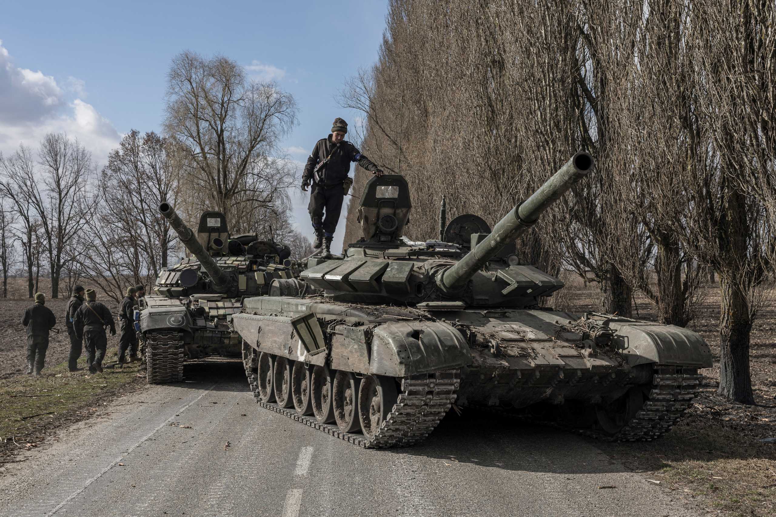 A Ukranian serviceman stands on top of a Russian tank captured after fighting with Russian troops in the village of Lukyanivka outside Kyiv, Ukraine as Russia's invasion of the country continues, March 27, 2022. REUTERS