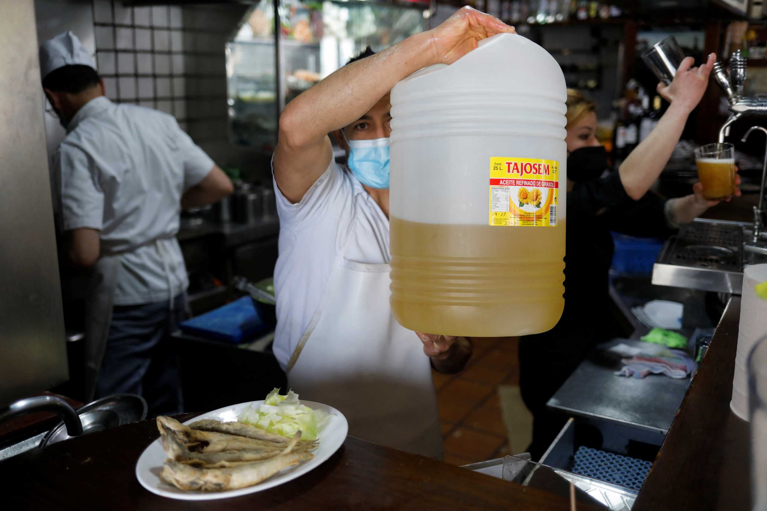 A waiter holds a plastic bottle with sunflower oil used to fry fish at Los Cazadores bar in Ronda, Spain, March 19, 2022. Picture taken March 19, 2022. REUTERS