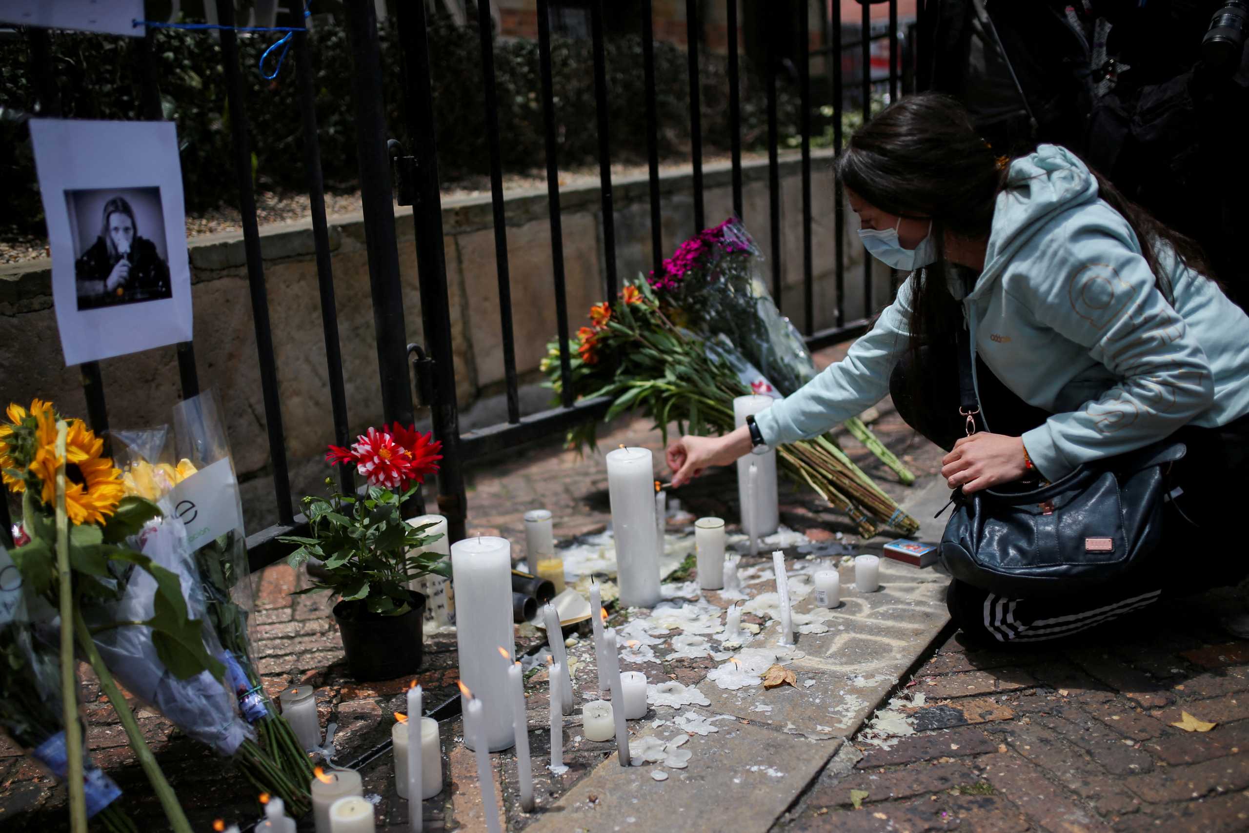A woman lights candles outside the Casa Medina hotel where Taylor Hawkins, the band's drummer, died before appearing at the Estereo Picnic festival in Bogota, Colombia March 26, 2022. REUTERS