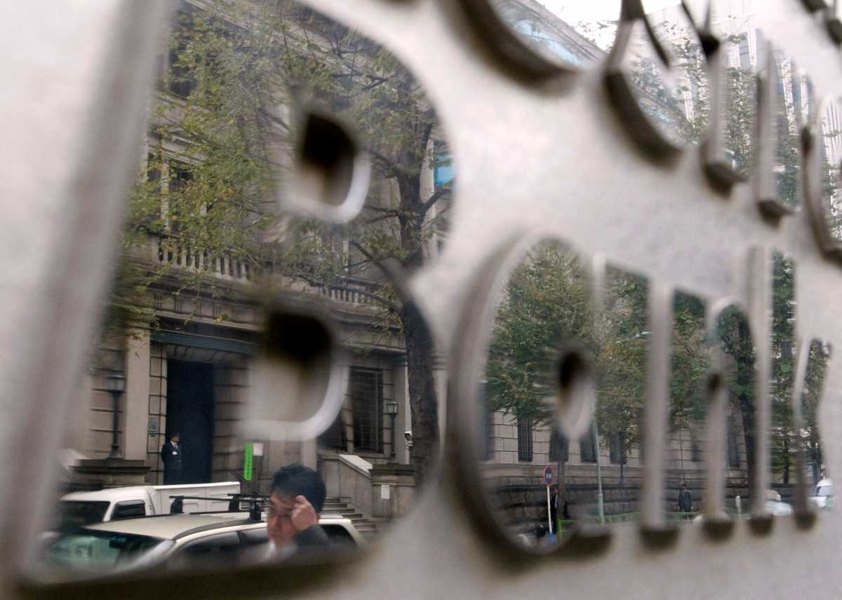 FILE PHOTO: The Bank of Japan (BOJ) building is reflected on the signboard of a bank in Tokyo November 24, 2009.REUTERS