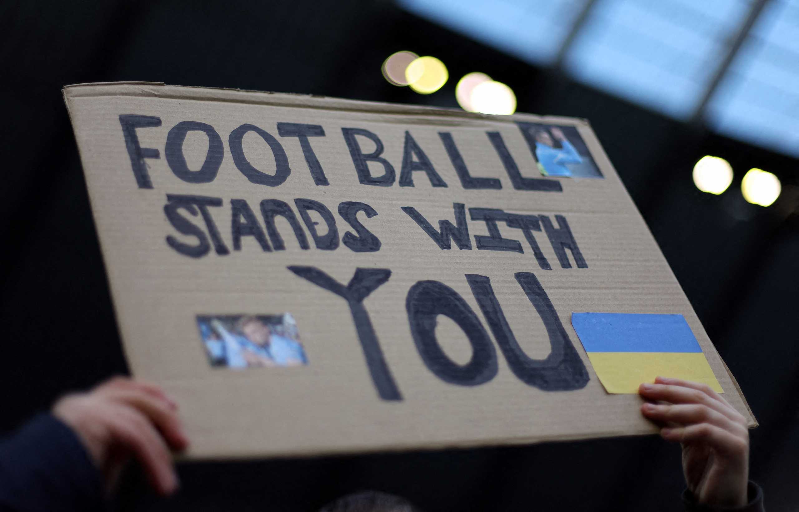 Soccer Football - Premier League - Manchester City v Manchester United - Etihad Stadium, Manchester, Britain - March 6, 2022 A fan holds a banner in support of Ukraine amid Russia's invasion before the match Action Images via Reuters