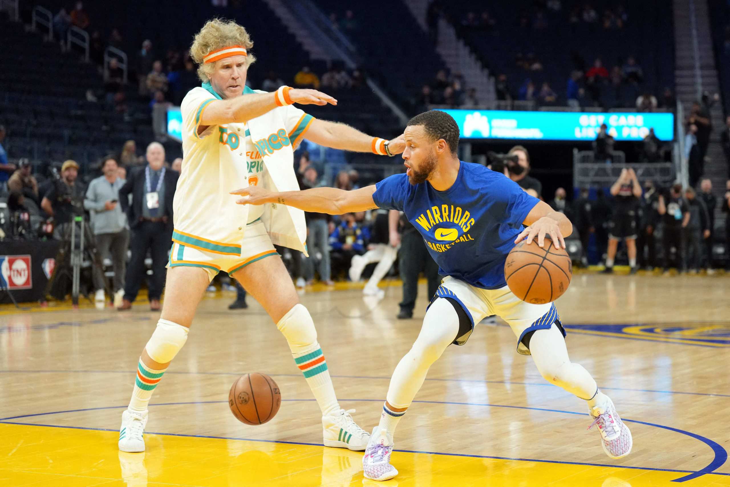 Mar 8, 2022; San Francisco, California, USA; Golden State Warriors guard Stephen Curry (30) warms up as comedian Will Ferrell stands on the court before the game against the LA Clippers at Chase Center. Mandatory Credit: Darren Yamashita-USA TODAY Sports
