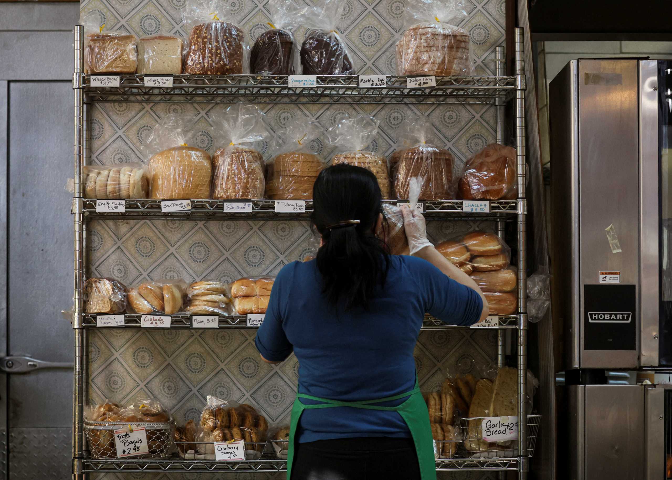 A baker stocks shelfs with bread at the Eastern Market in Washington, U.S., February 11, 2022. REUTERS
